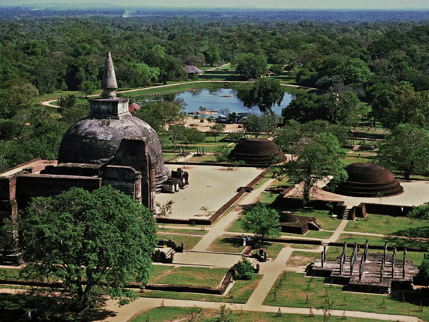 Luftaufnahme der Ruinen der Königsstadt Polonnaruwa in Sri Lanka mit alten Dagobas und Tempeln, umgeben von dichtem Dschungel.