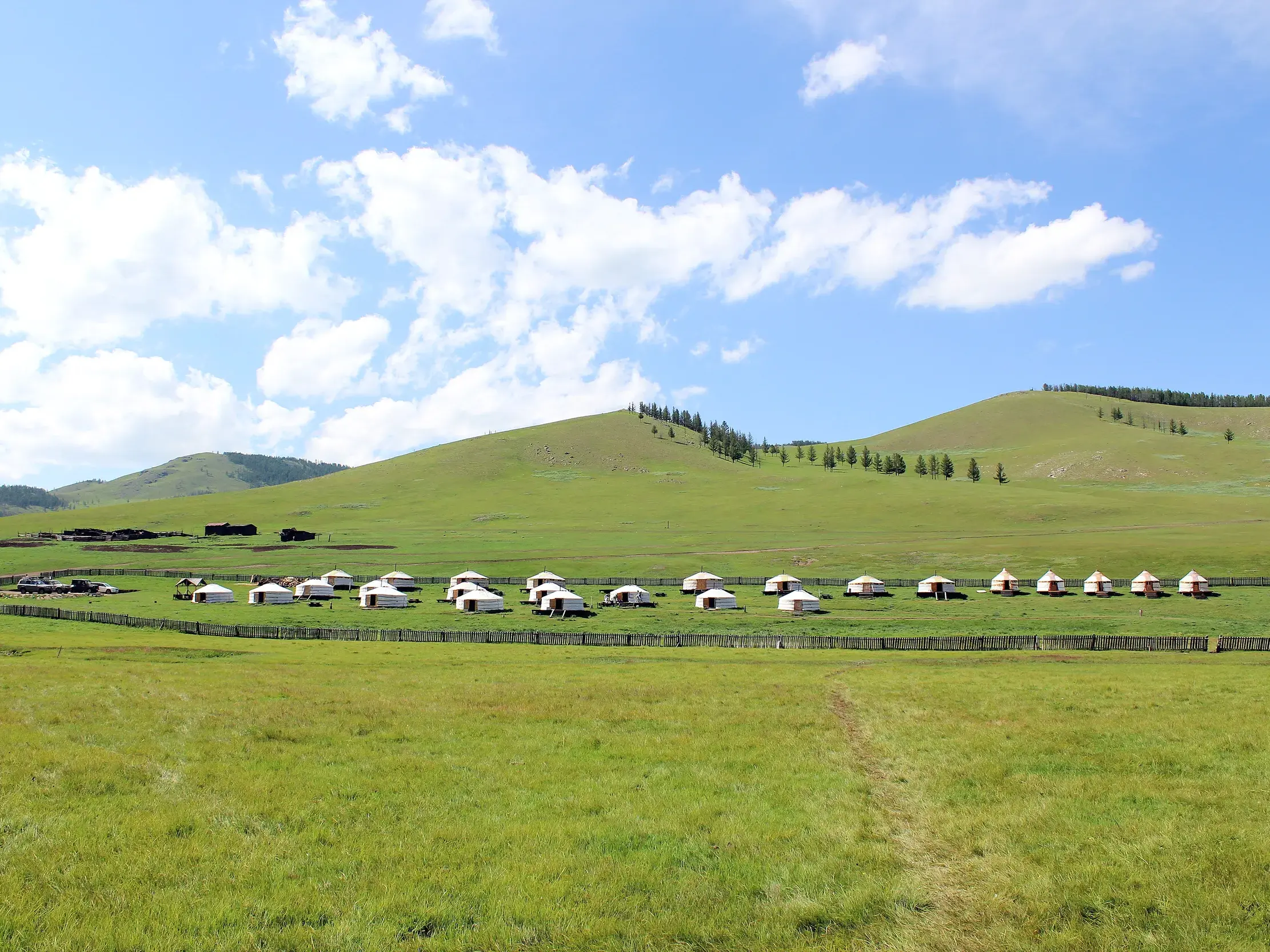 Ein traditionelles Jurtenlager für die Übernachtung auf einer Wanderreise in der weiten, grünen Steppe der Mongolei.