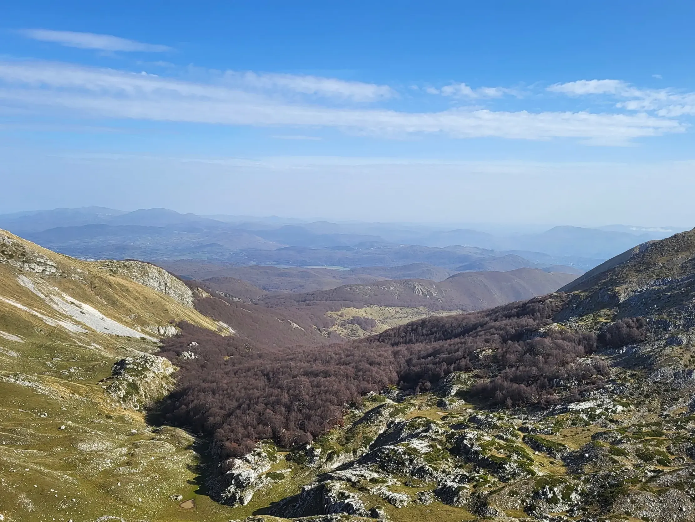 Weitblick über ein Tal mit Buchenwäldern auf die wilden Gebirgsketten im Nationalpark der Abruzzen, Latium und Molise.