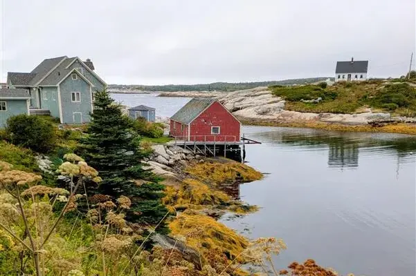 Typisch rote Fischerhütte auf Stelzen in einer felsigen Bucht an der Küste von Nova Scotia in Ostkanada.