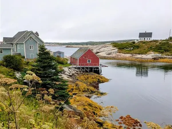 Typisch rote Fischerhütte auf Stelzen in einer felsigen Bucht an der Küste von Nova Scotia in Ostkanada.