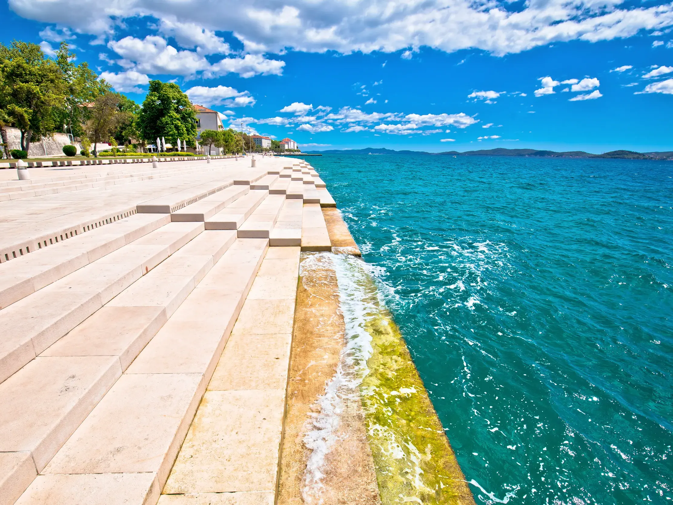 Einzigartige Steintreppe der Meeresorgel in Zadar, an der die Wellen der türkisfarbenen Adria sanft auslaufen.