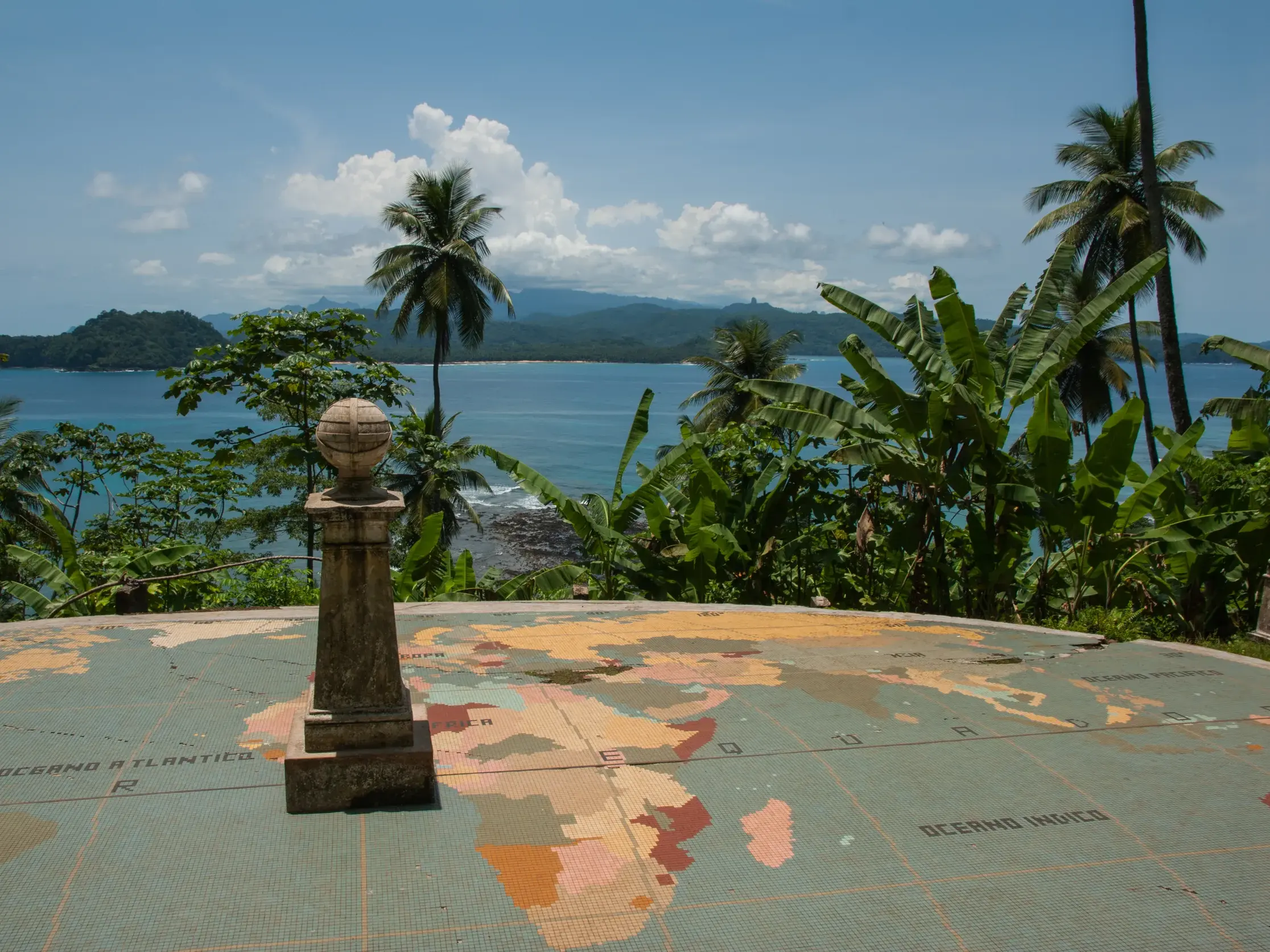 Am Äquator-Denkmal auf der Insel Ilhéu das Rolas mit Panoramablick über tropischen Regenwald und die Küste von São Tomé.
