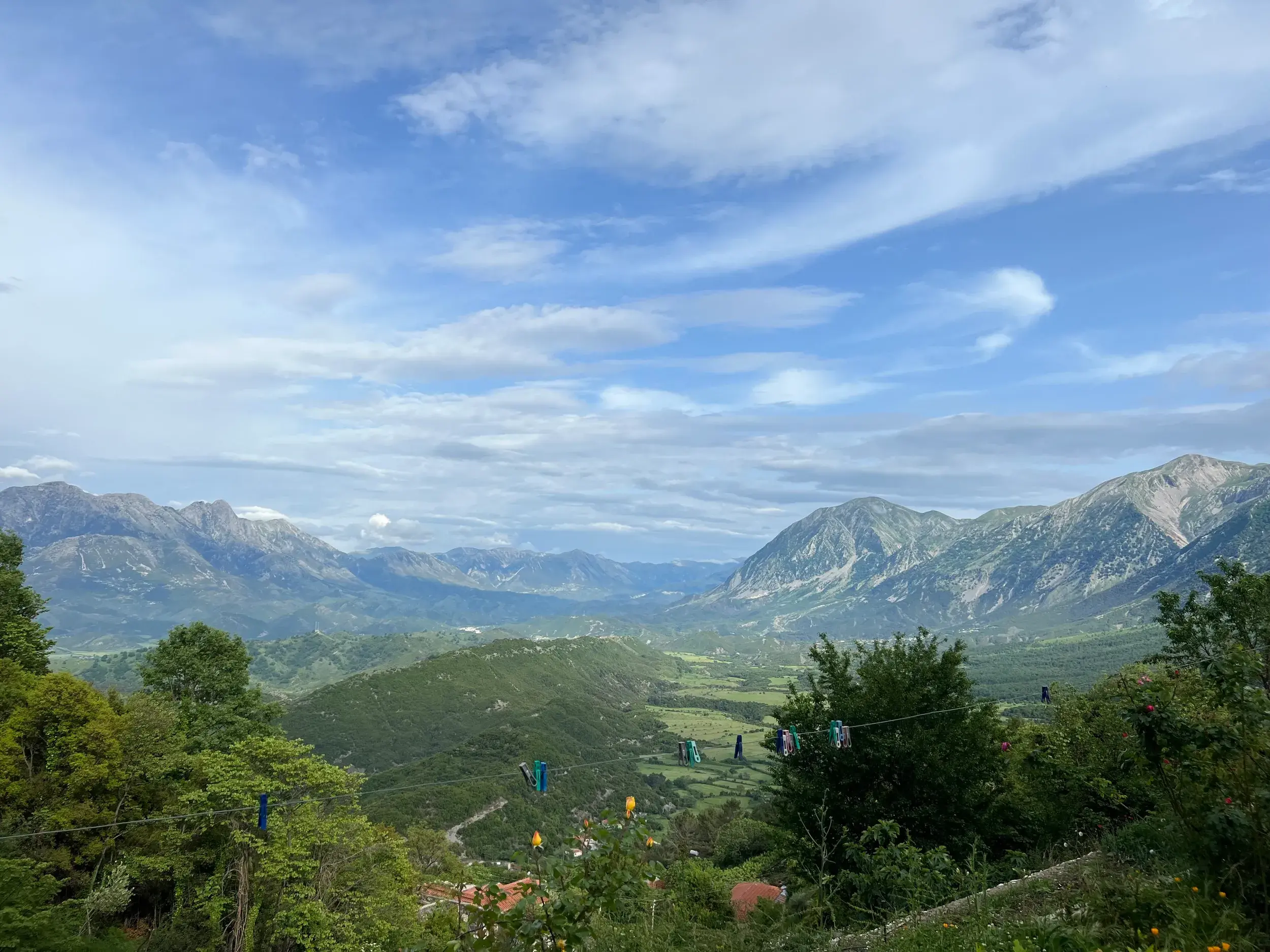 Weitblick von einem Gästehaus über das grüne Shushica-Tal während einer Trekkingreise in den albanischen Bergen.
