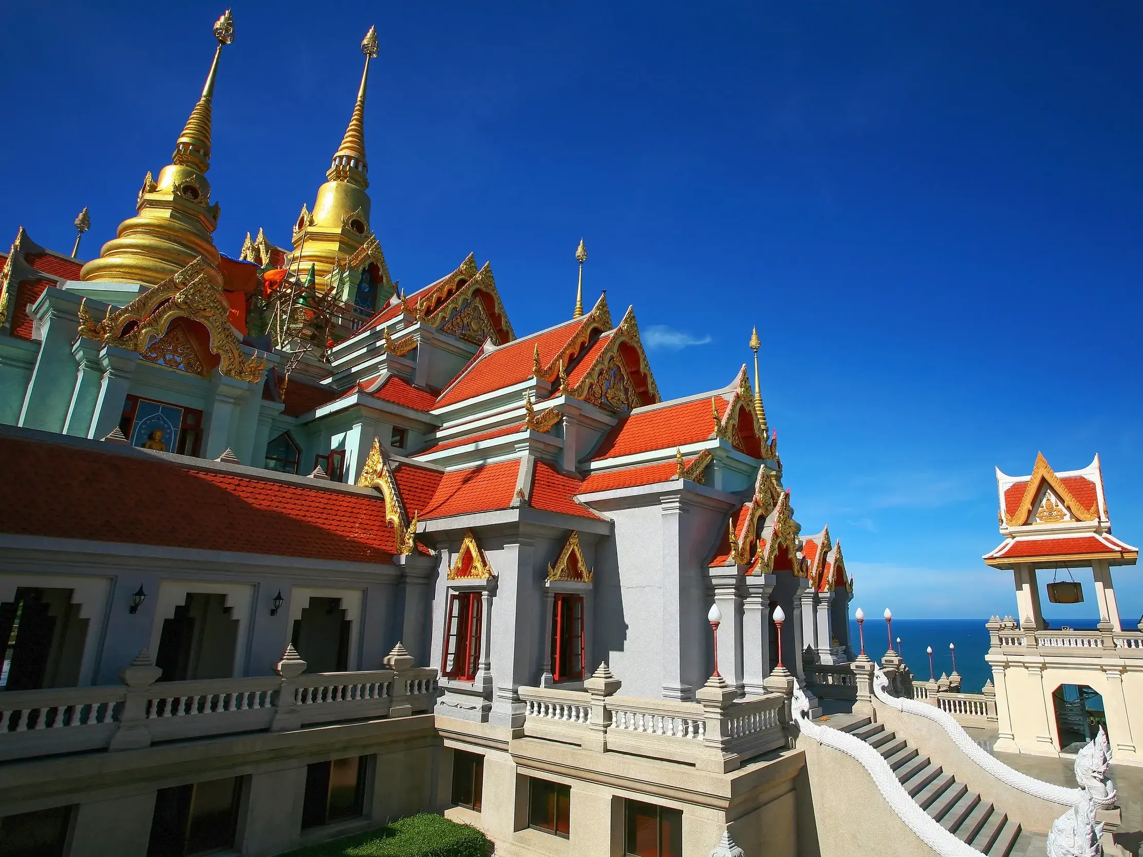 Prachtvolle Tempelanlage Wat Thang Sai auf dem Berg Thong Chai mit goldenen Spitzen und weitem Blick über die Küste Thailands.