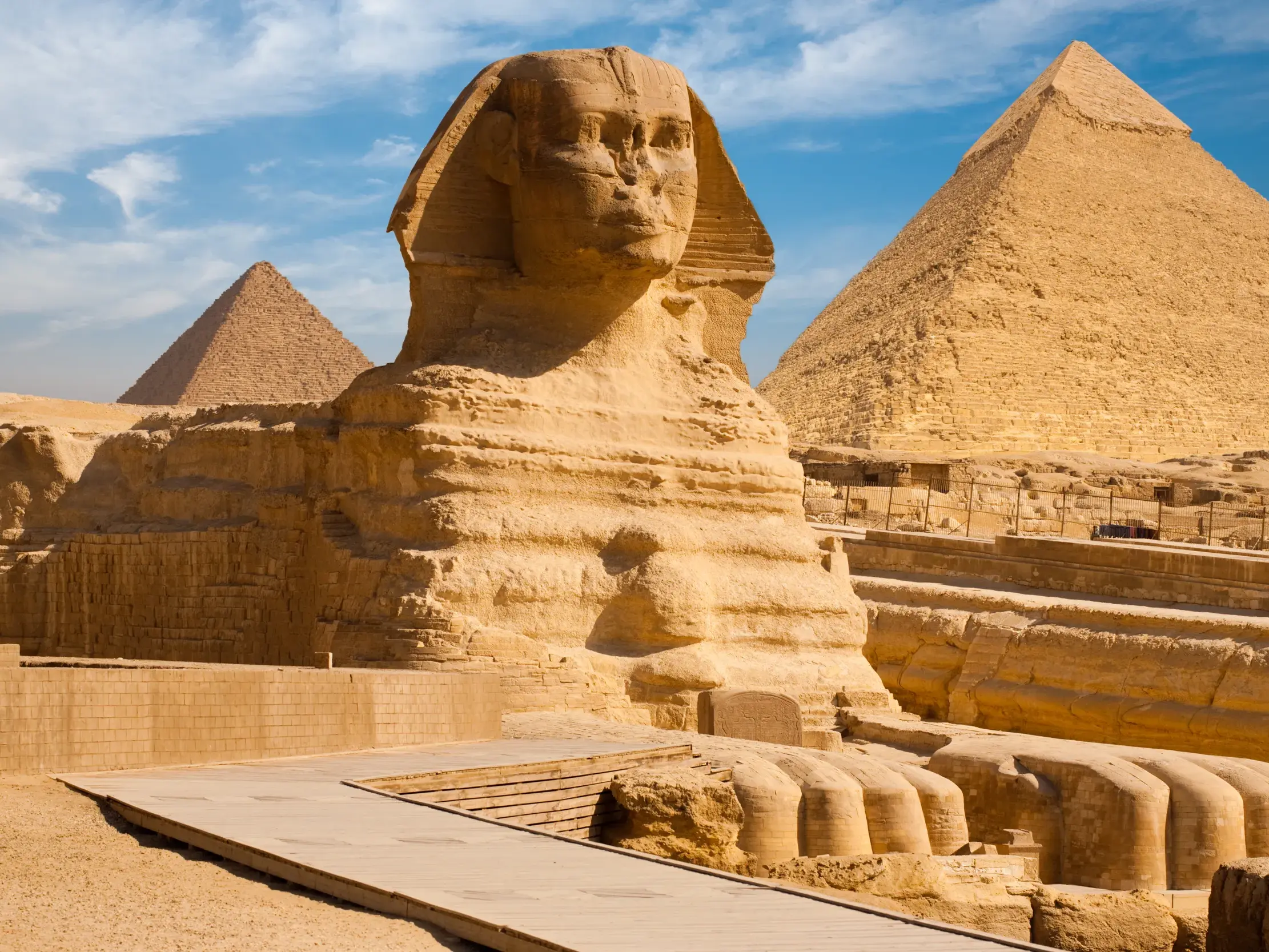 Die imposante Große Sphinx von Gizeh wacht vor den weltberühmten Pyramiden unter blauem Himmel in der Wüste Ägyptens.