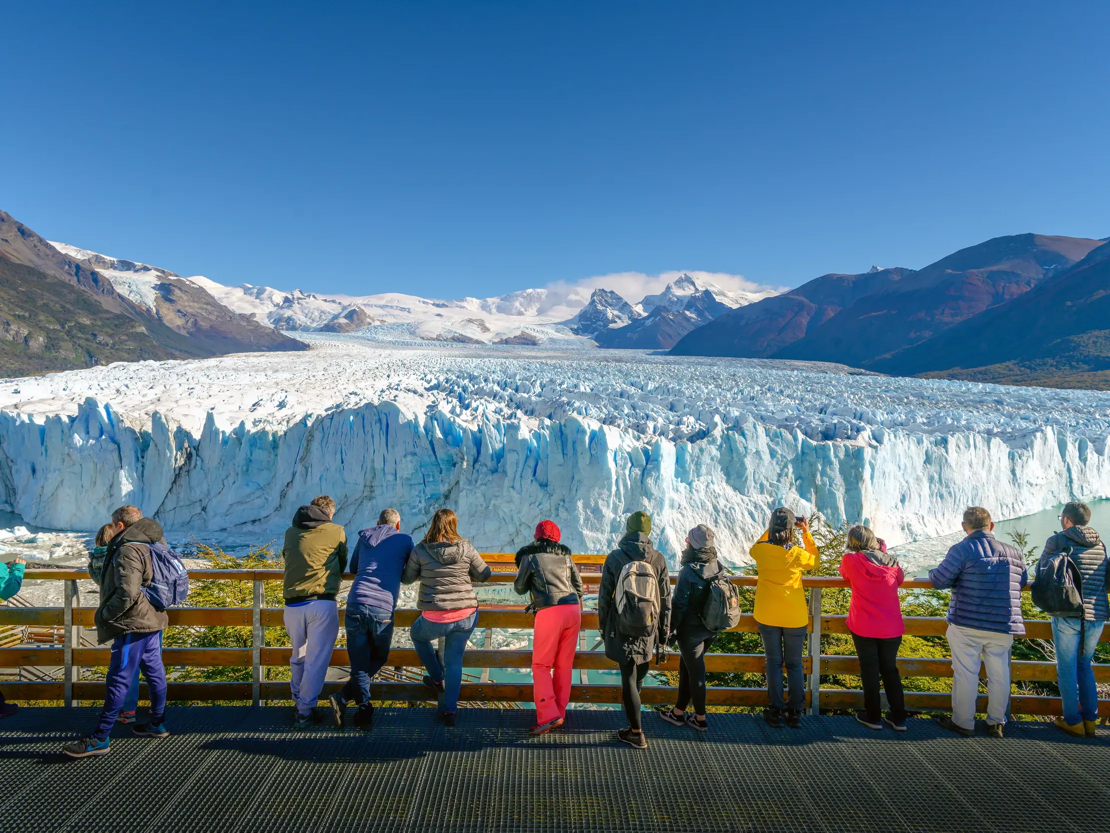 Eine Gruppe auf einer Studienreise bestaunt von einer Plattform den Perito-Moreno-Gletscher im Nationalpark Los Glaciares.