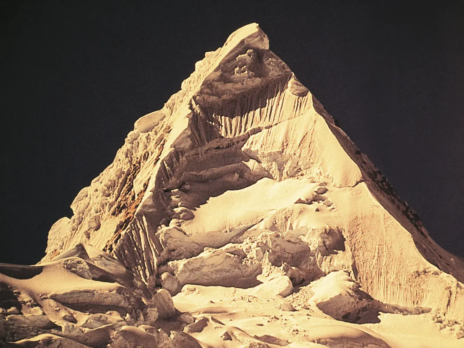 Die schneeweiße Pyramide des Alpamayo in der Cordillera Blanca, von der Morgensonne beleuchtet während einer Trekkingreise in Peru.