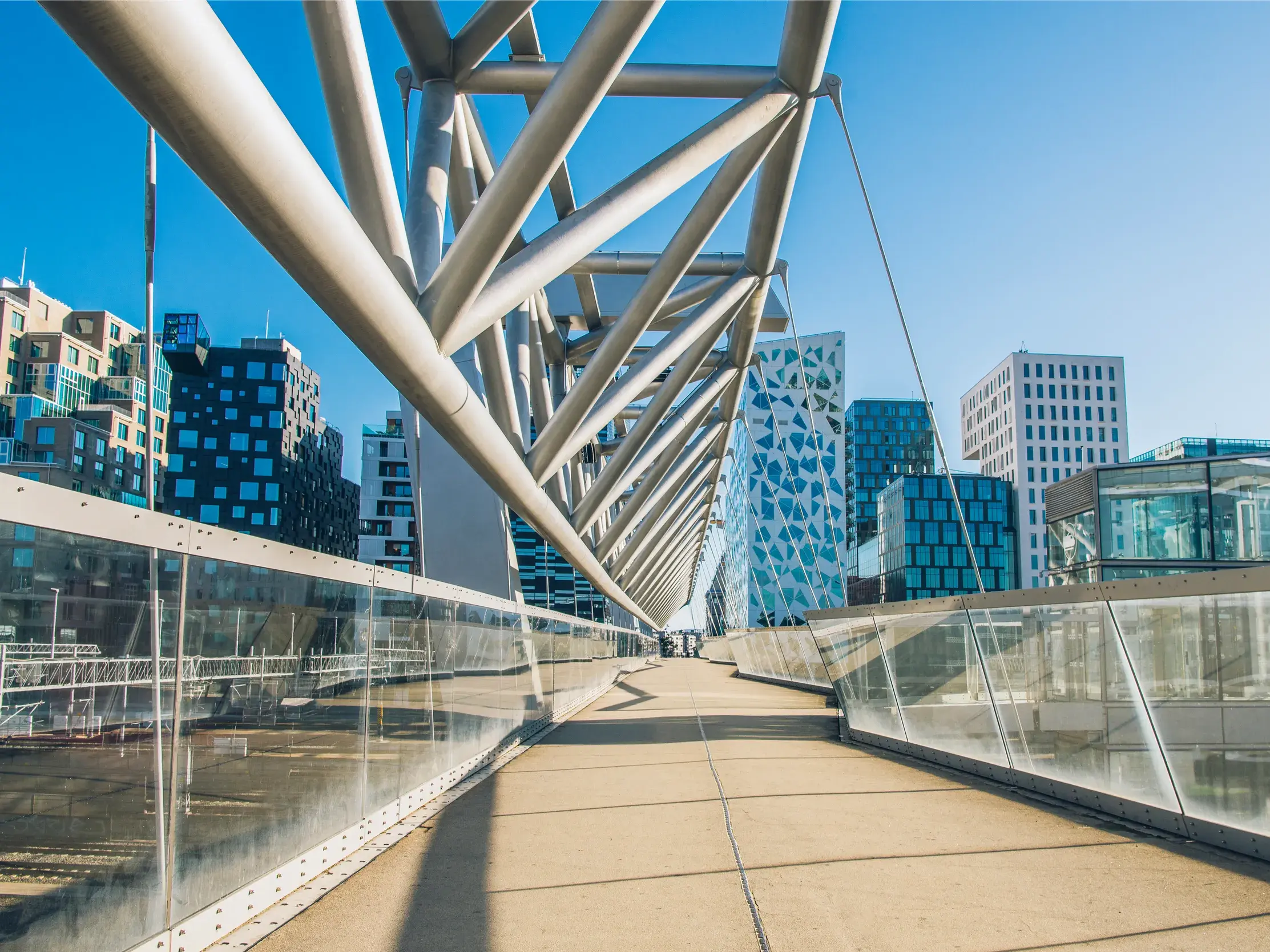 Sonniger Tag in Oslo: Blick über die Fußgängerbrücke Akrobaten auf die modernen Gebäude des Barcode-Viertels.