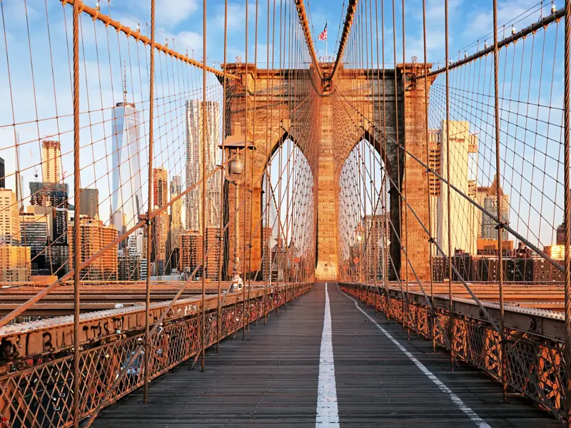 Zu Fuß überqueren Sie mit Ihrer Studiosus Reiseleitung die Brooklyn Bridge mit Blick auf die Wolkenkratzer von Manhattan und das One World Trade Center.
