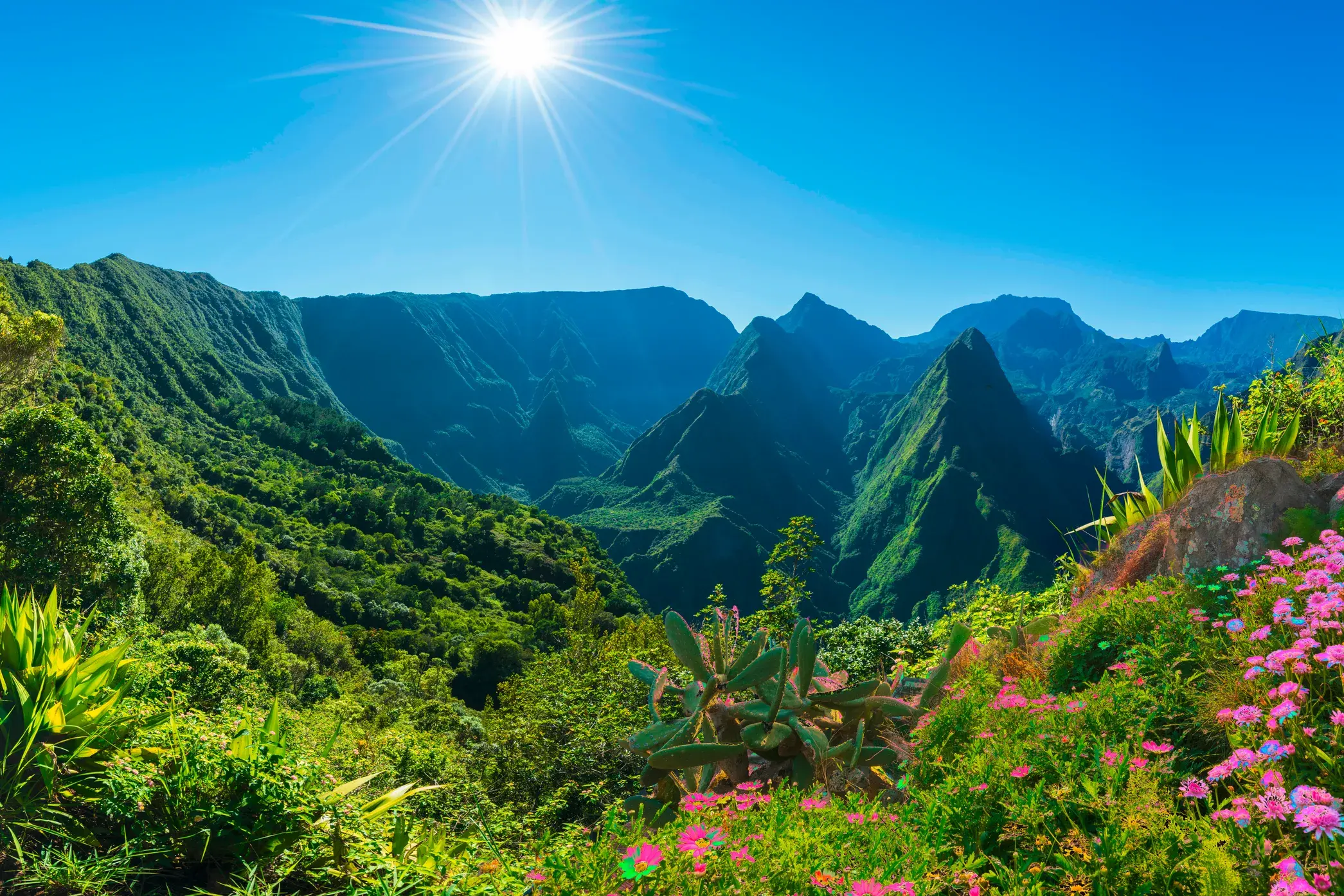 Spektakulärer Ausblick vom Piton Maido auf den sonnenbeschienenen, grünen Talkessel des Cirque de Mafate auf La Réunion.