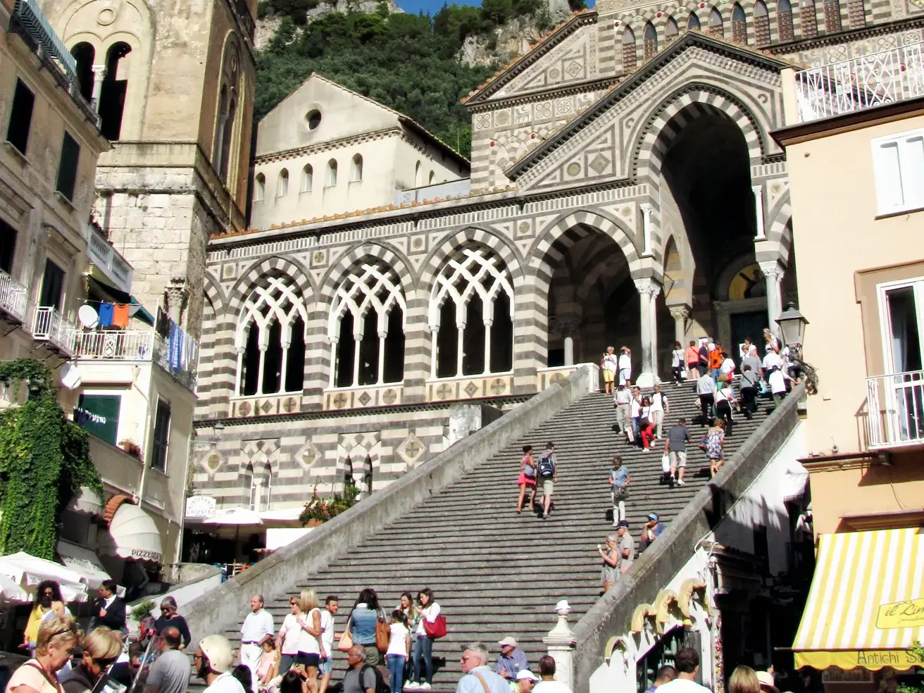 Zahlreiche Besucher auf der markanten Freitreppe des Doms Sant' Andrea in Amalfi an der sonnigen Amalfiküste.