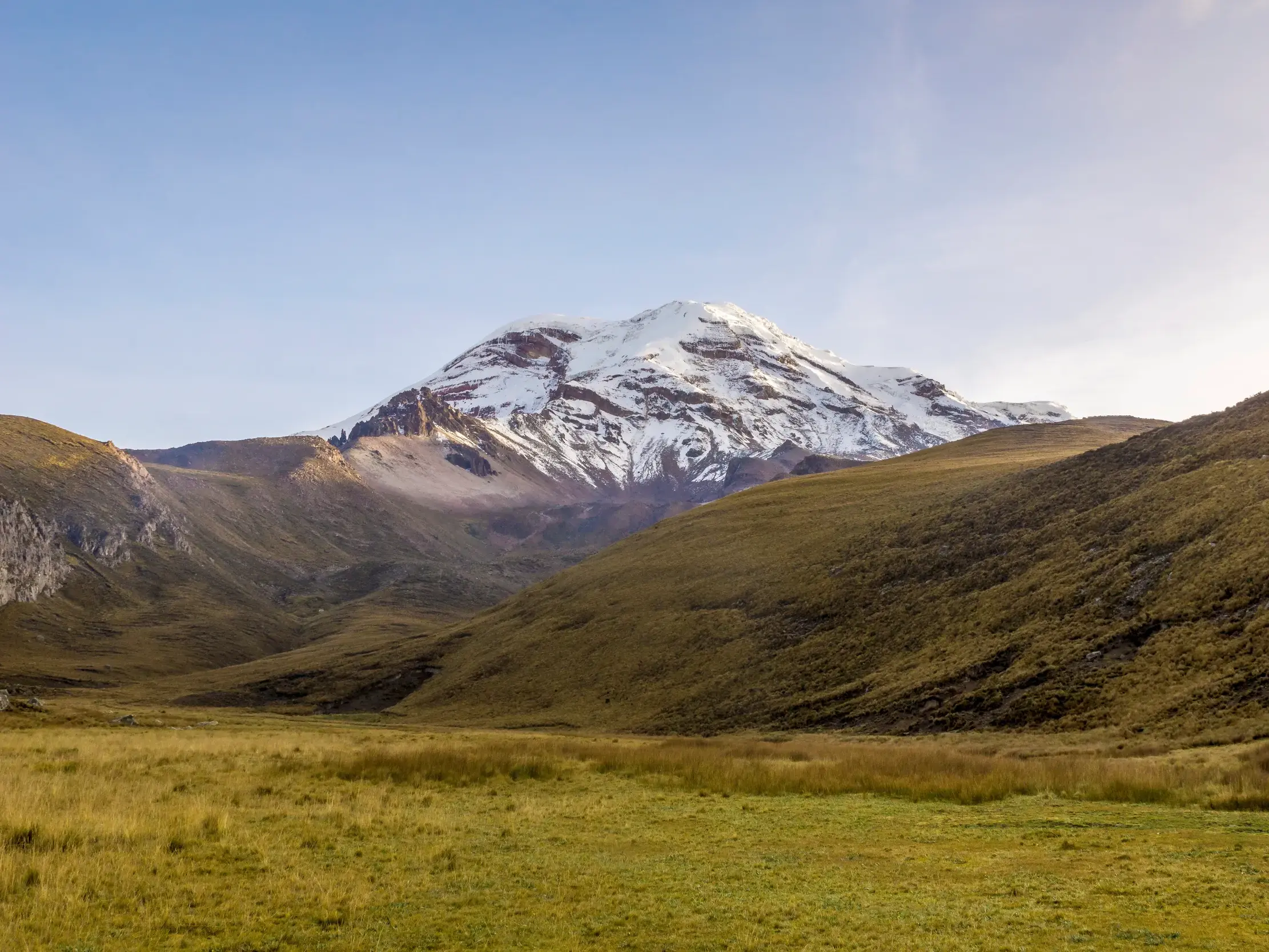 Majestätischer Blick auf den schneebedeckten Gipfel des Chimborazo Vulkans vom grünen Abraspungotal in Ecuador.