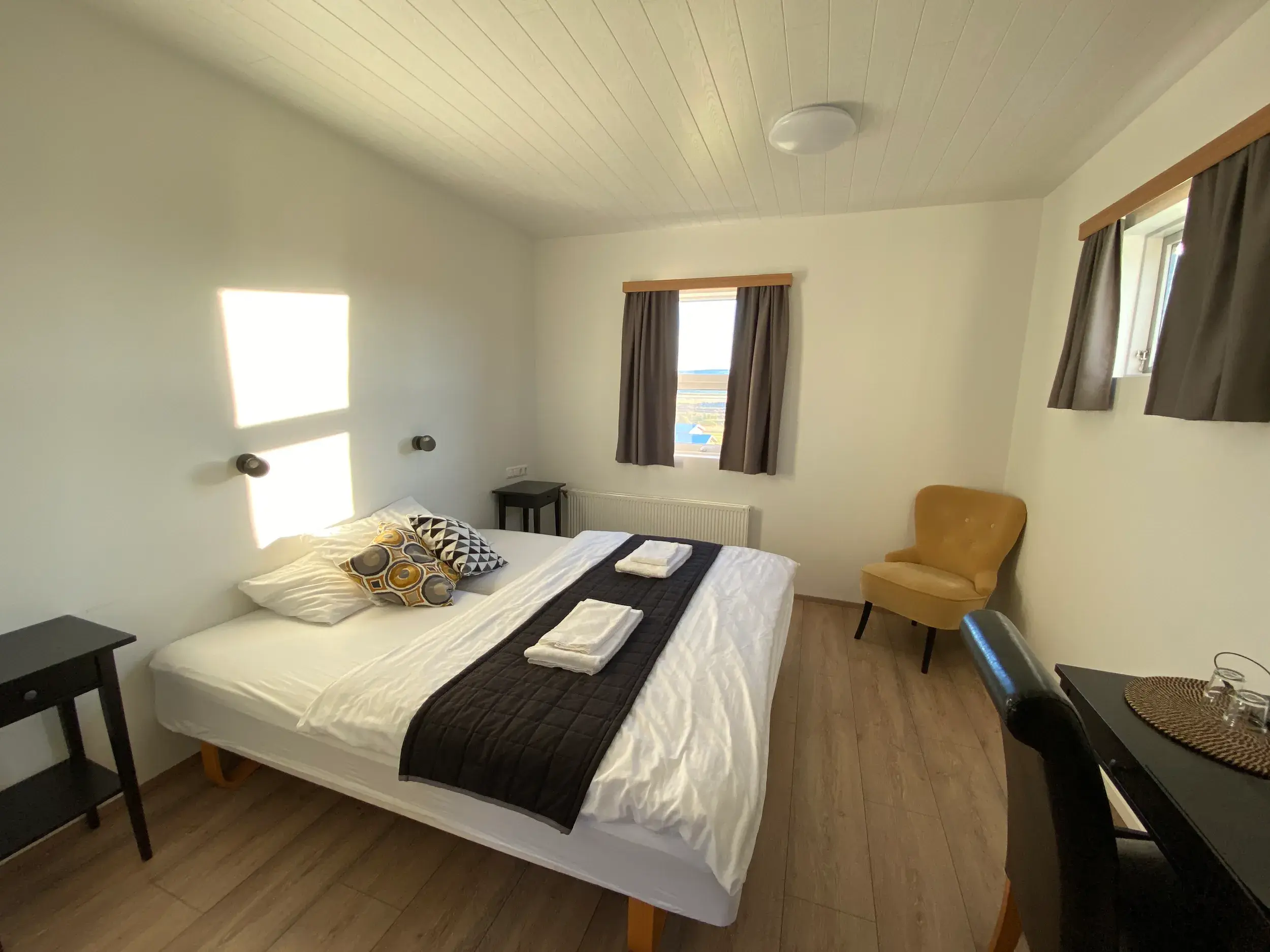 Helles, einladendes Zimmer im isländischen Gästehaus mit Holzboden, ein gemütlicher Rückzugsort nach einer langen Wanderung.
