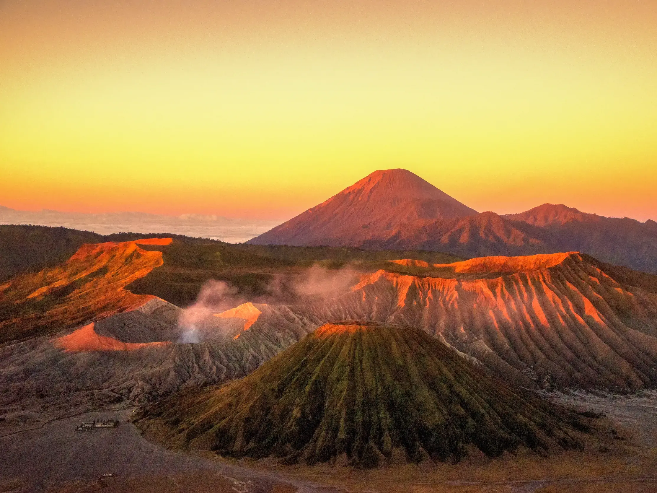 Atemberaubender Sonnenaufgang über der Vulkanlandschaft des Bromo-Nationalparks mit dem rauchenden Krater des Mt. Bromo.