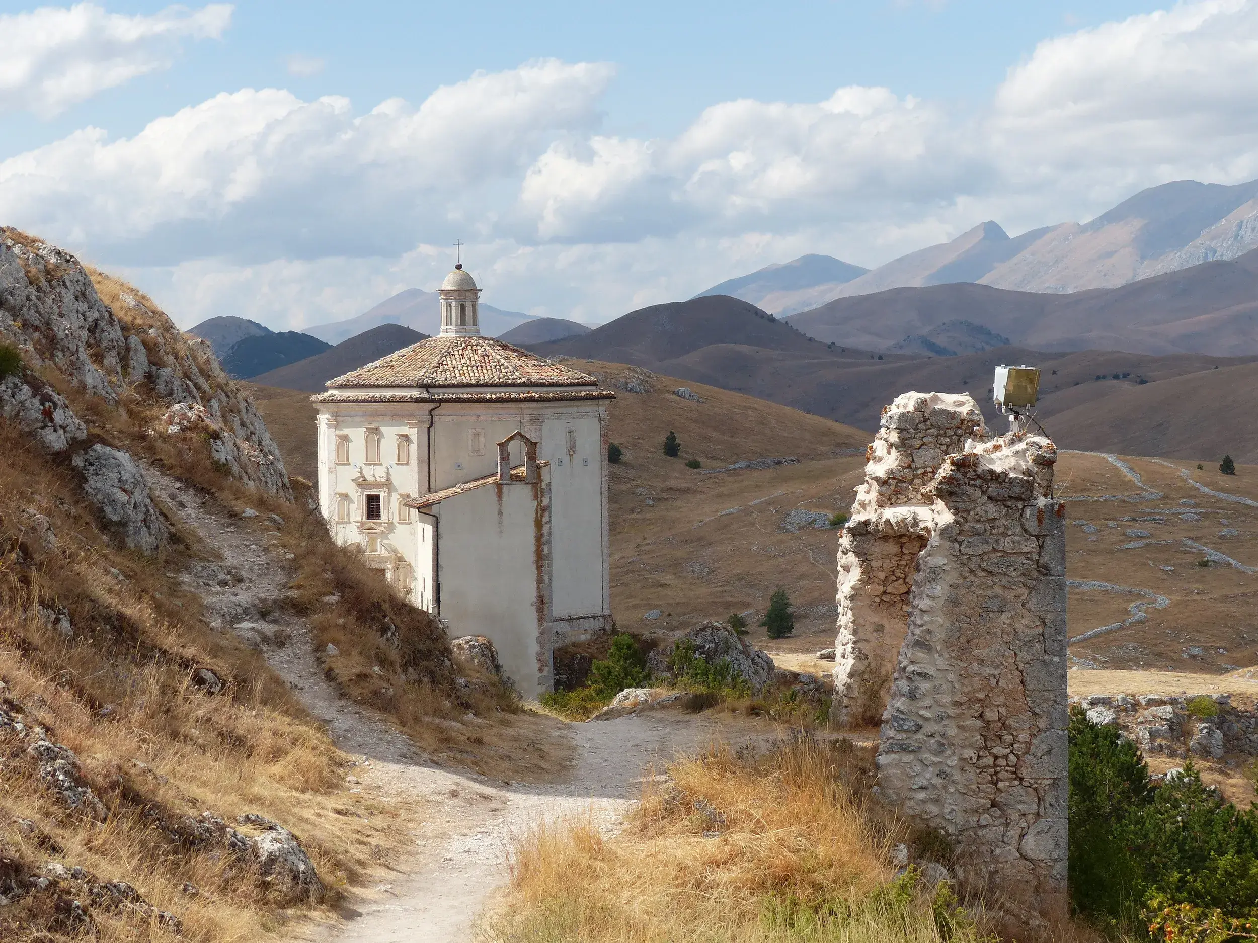 Wanderweg entlang einer Ruine zur Kirche Santa Maria della Pietà bei Rocca Calascio im Nationalpark Gran Sasso.