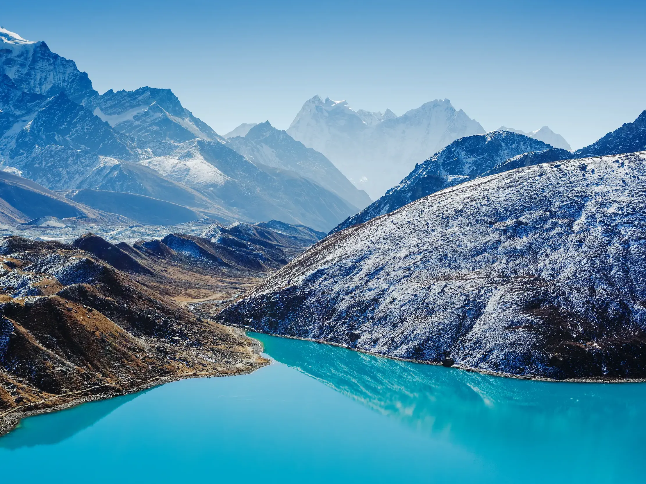 Panoramablick vom Gipfel des Gokyo Ri auf den leuchtend türkisfarbenen Gokyo-See und die schneebedeckten Achttausender Nepals.