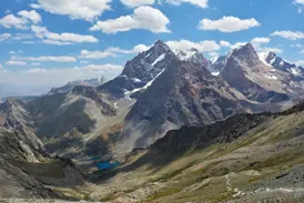 Panoramablick beim Trekking im Fan-Gebirge über ein Tal mit den türkisen Alaudin-Seen auf schneebedeckte Fünftausender.