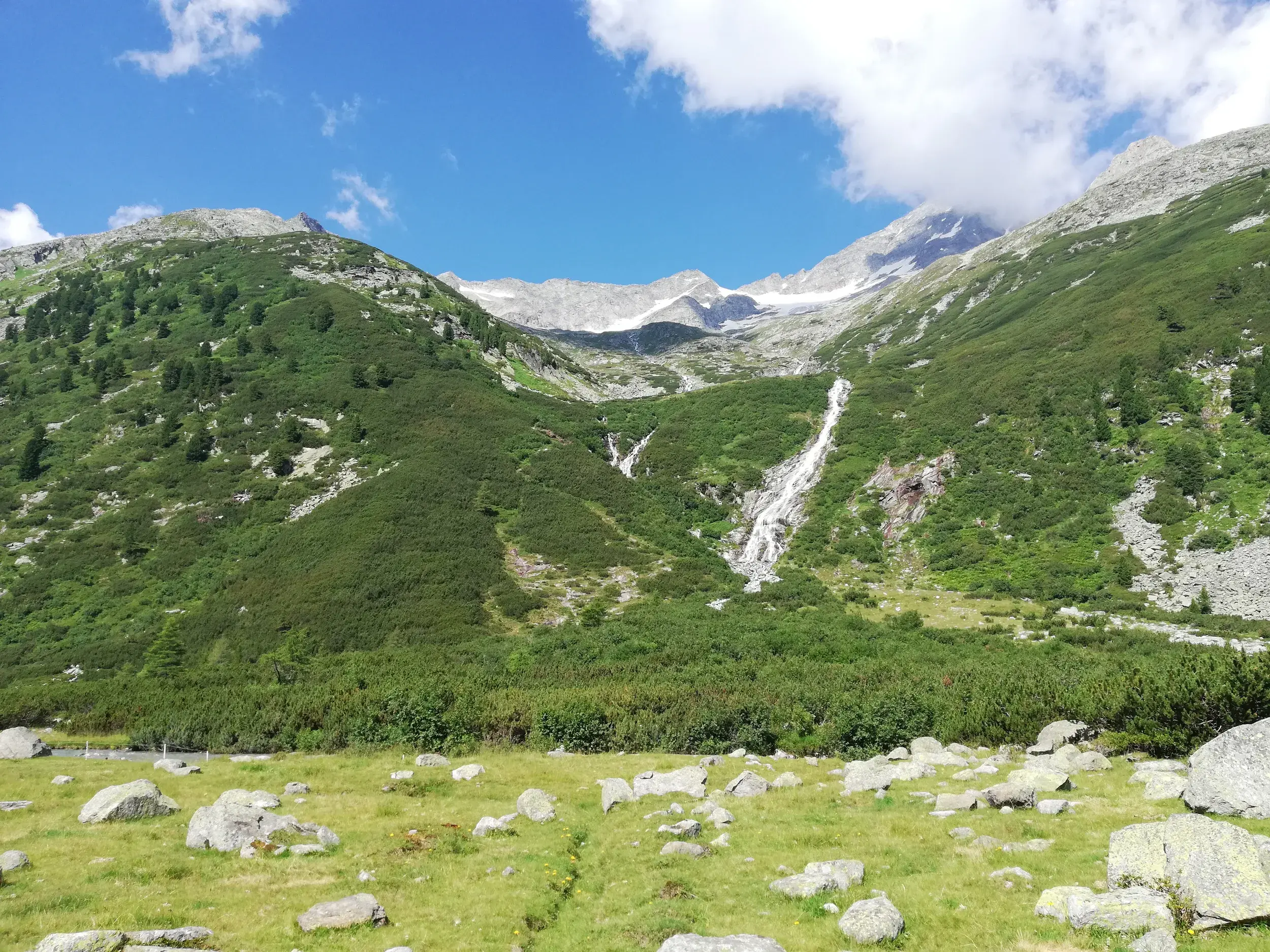 Ein rauschender Wasserfall im Pfitschtal auf der Wanderung zum Pfitscher Joch während einer Alpenüberquerung in Südtirol.
