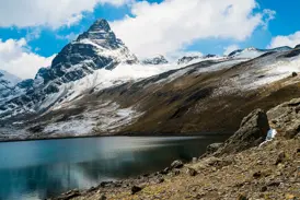 Majestätischer Blick auf den pyramidenförmigen Alpamayo und einen tiefblauen See während des Trekkings in der Cordillera Blanca.