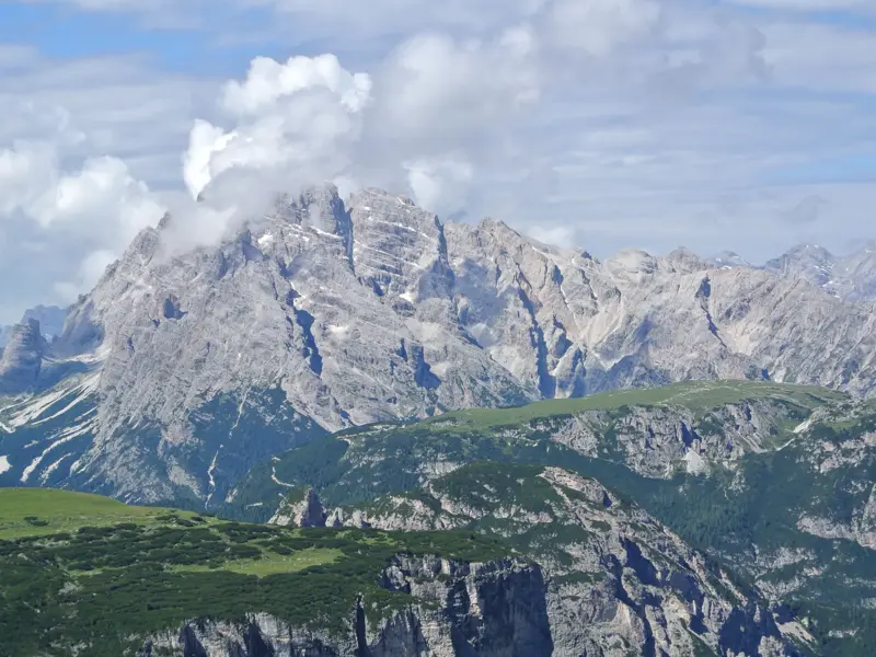 Weitblick auf die majestätischen, zerklüfteten Gipfel der Sextener Dolomiten über grünen Almwiesen in Südtirol.