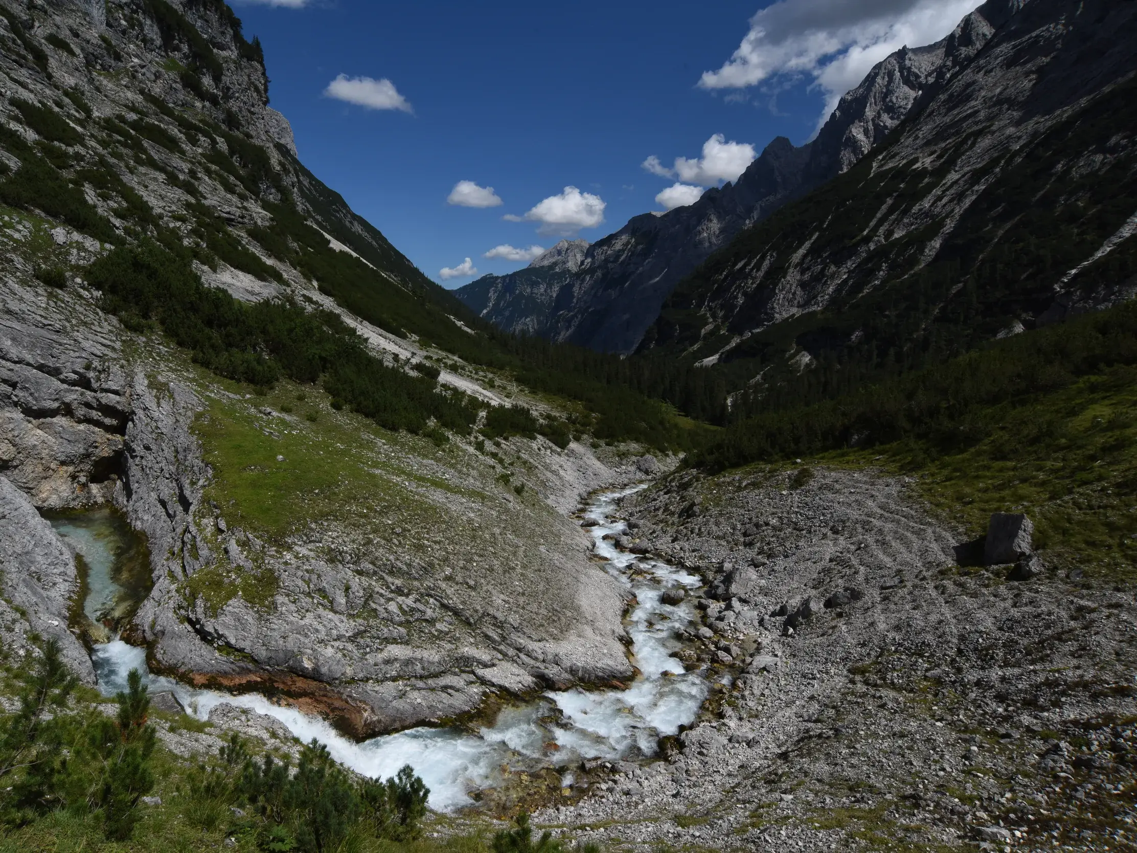 Die rauschende Partnach schlängelt sich durch das felsige und grüne Reintal auf dem Weg zur Zugspitze in den Alpen.