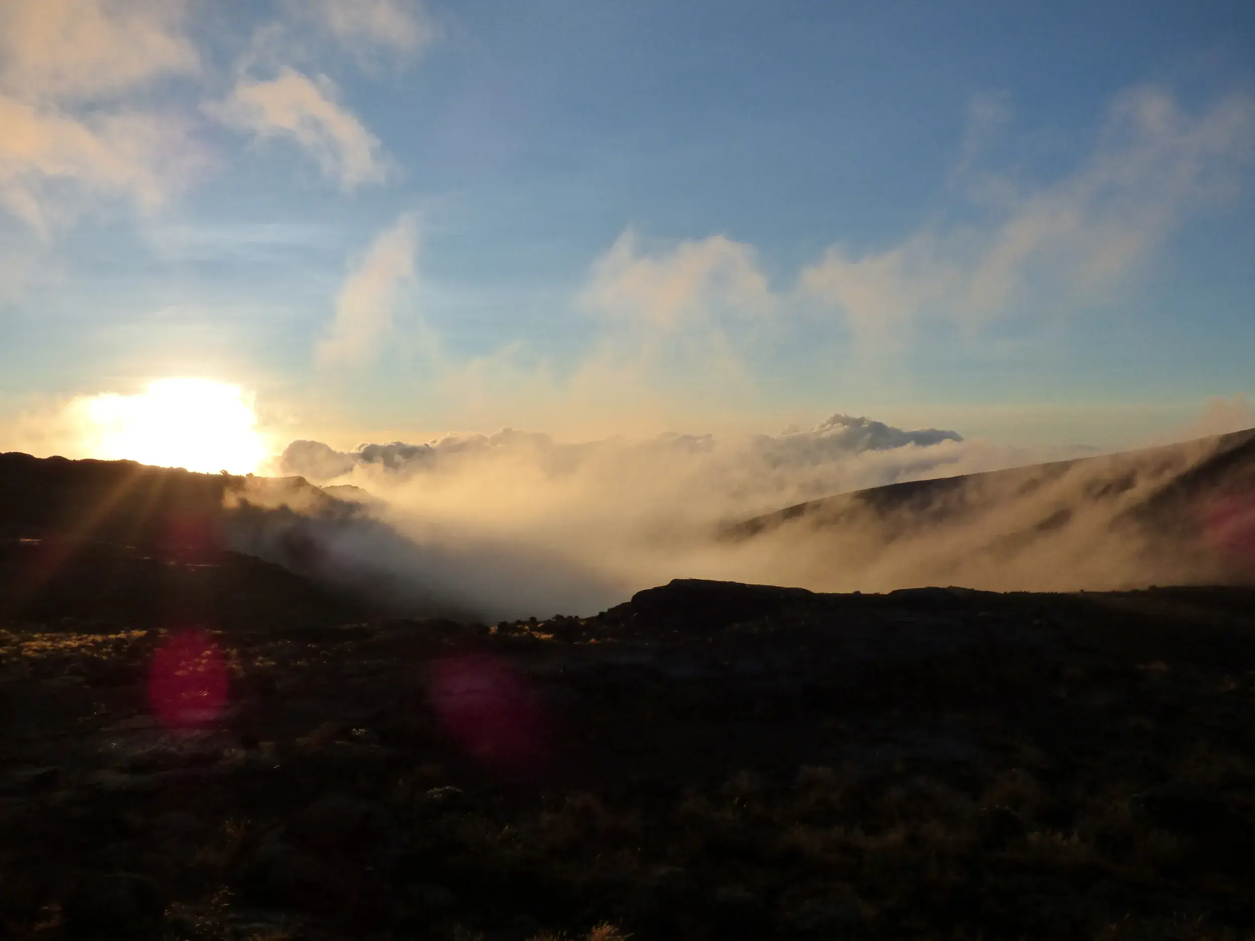 Spektakulärer Sonnenaufgang auf dem Kilimanjaro Trekking mit Blick über die Wolken auf dem Weg zum Gilman's Point in Tansania.