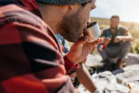 Teilnehmer einer Kleingruppenreise erfrischt sich während einer Pause im sonnigen Oman .