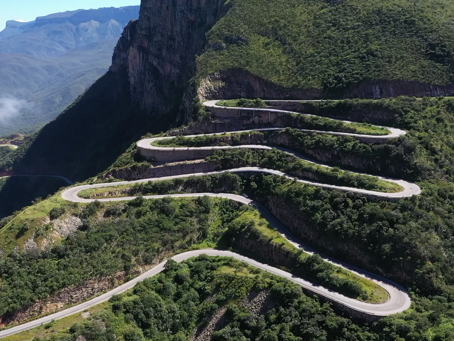 Die berühmte Passstraße Serra da Leba Pass in Angola schlängelt sich in engen Serpentinen den grünen, steilen Berghang hinauf.