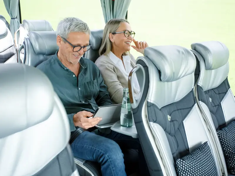 Ein Paar reist entspannt im modernen Studiosus-Komfortbus auf einer geführten Rundreise durch Europa.