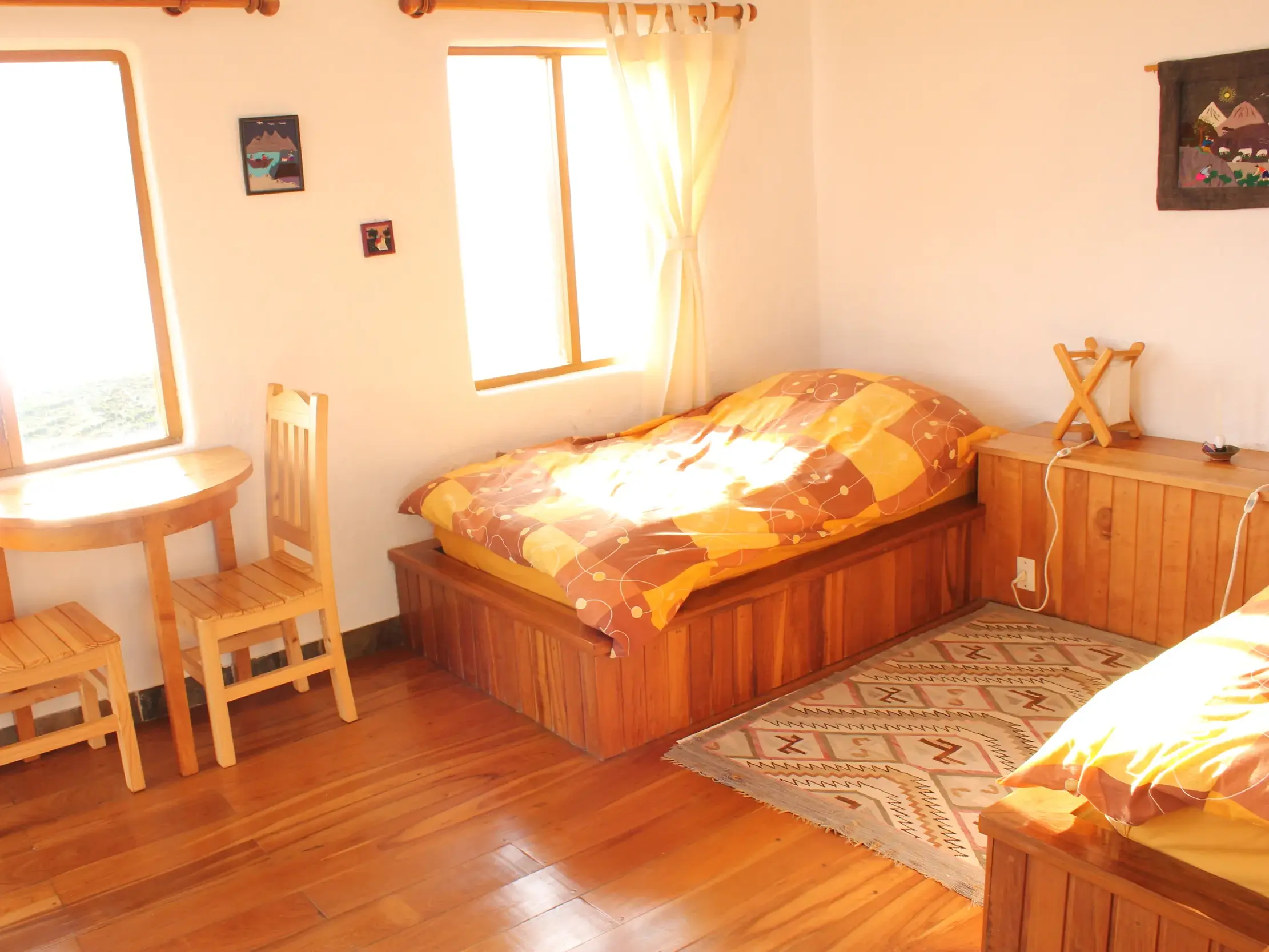 Helles, gemütliches Zimmer mit Holzmöbeln und landestypischer Deko in der Ecolodge La Estancia auf der Sonneninsel am Titicacasee.