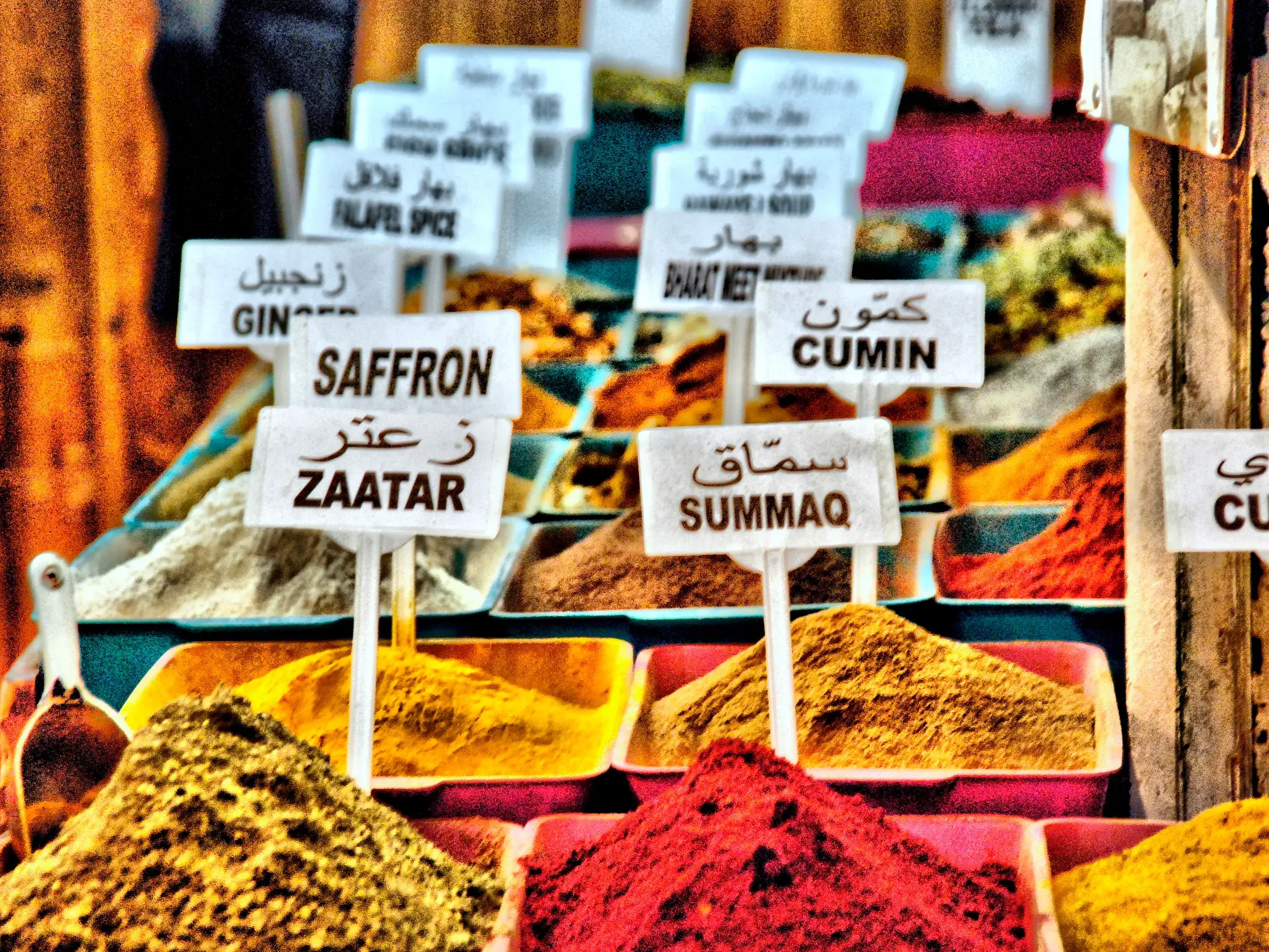 Bunte Gewürze wie Safran und Curry mit arabischen Schildern auf einem orientalischen Markt in Israel.