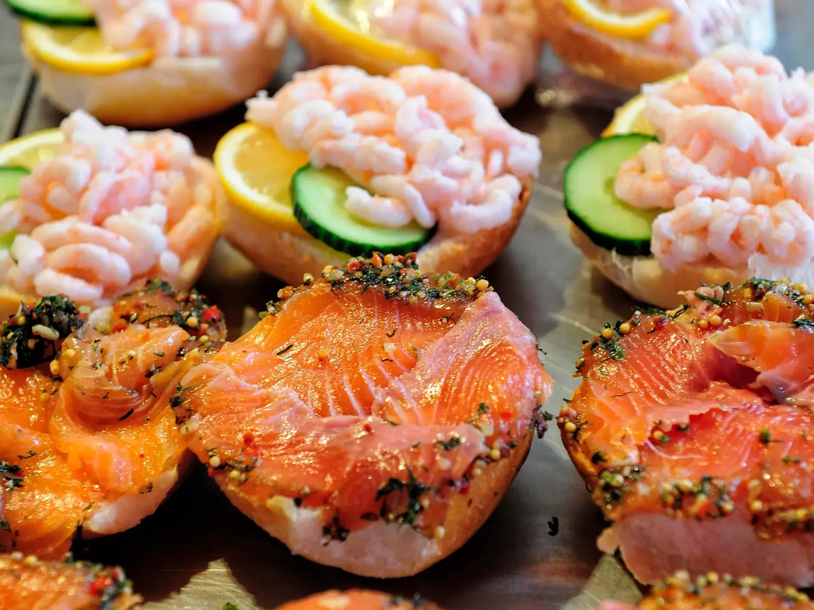 Nahaufnahme von appetitlich angerichteten skandinavischen Brötchen, belegt mit Graved Lachs und frischen Nordseekrabben.