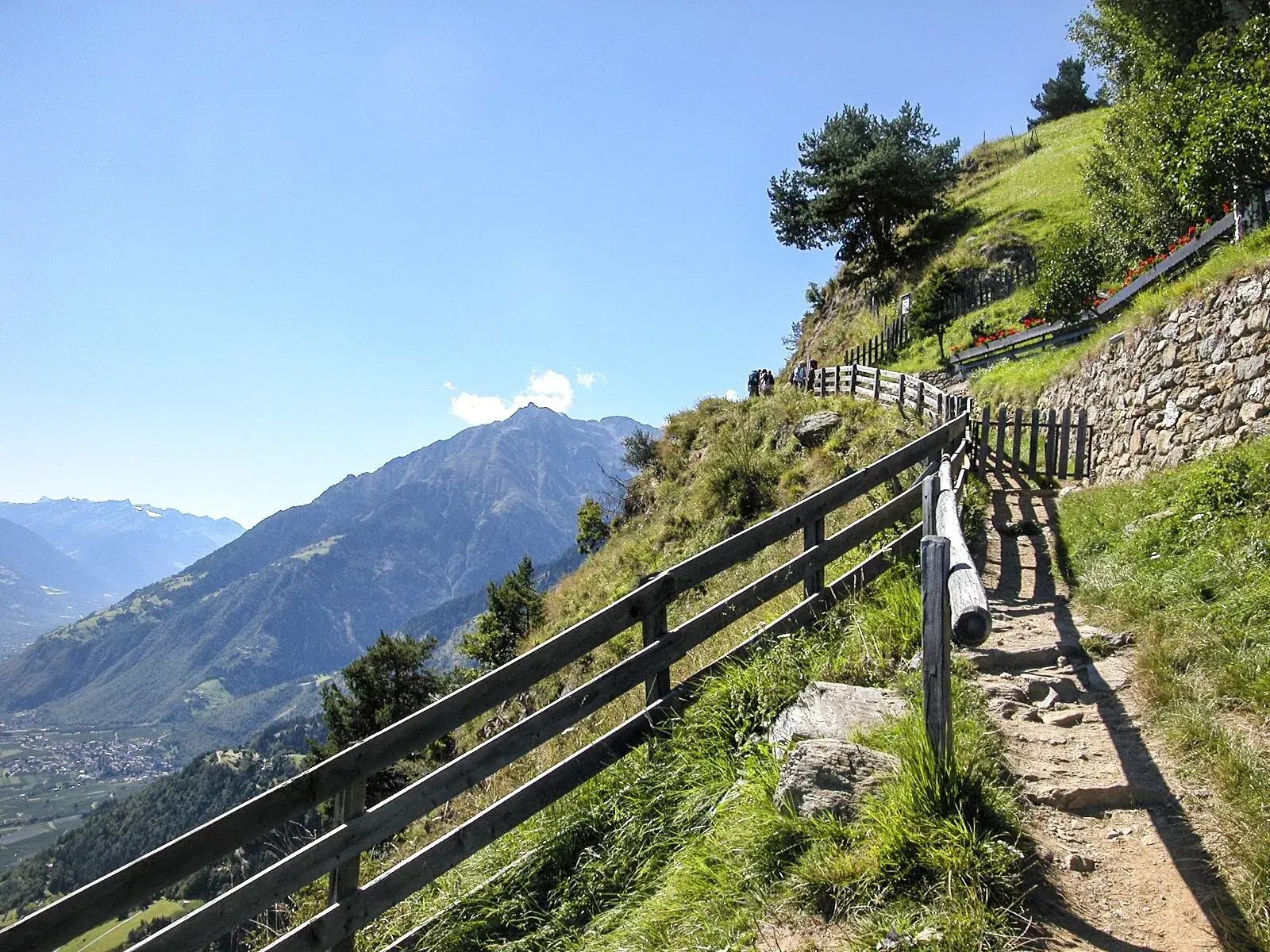 Wanderer auf dem Meraner Höhenweg in der Texelgruppe mit Panoramablick auf das Vinschgau und die Alpen in Südtirol.