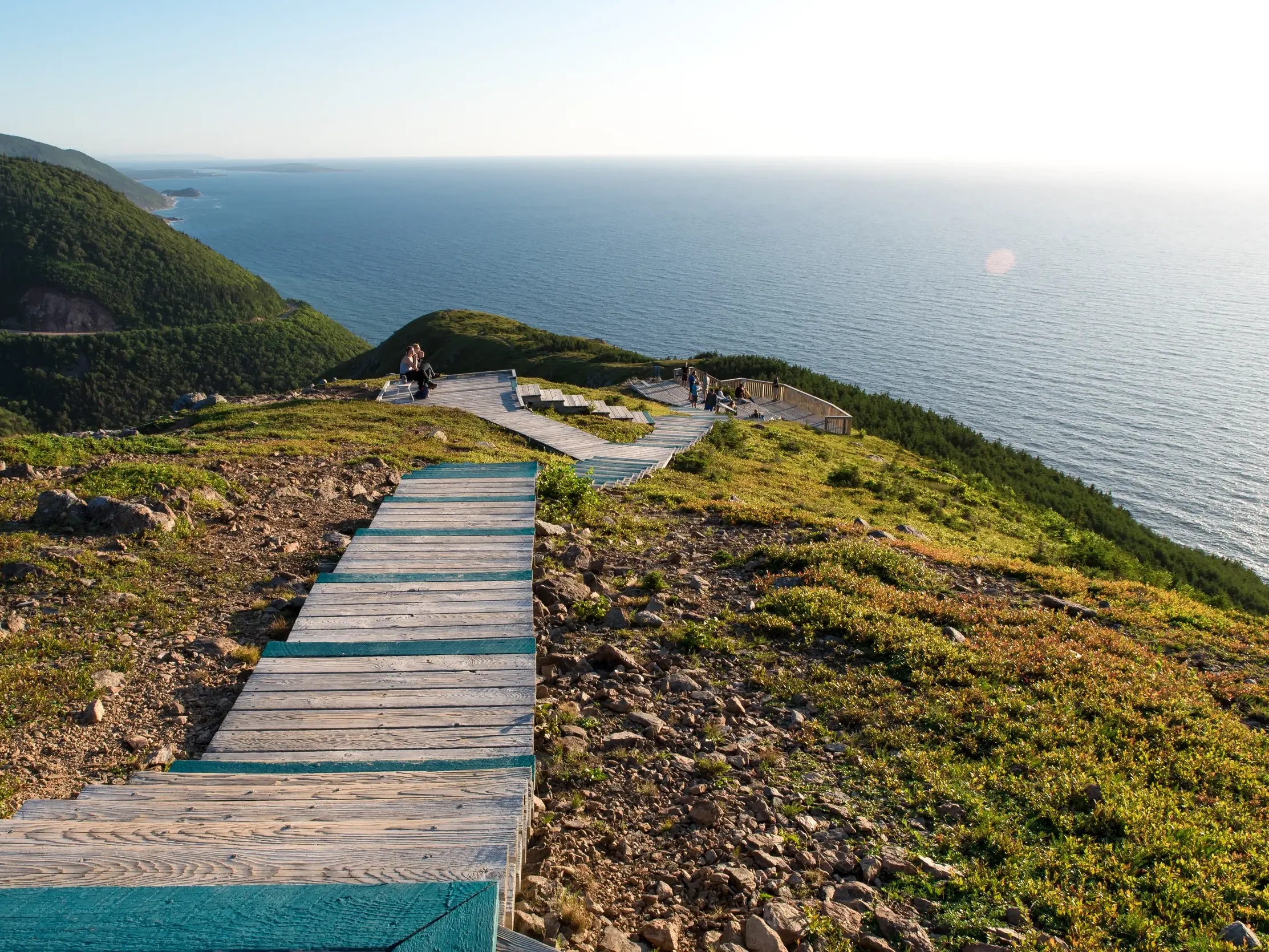 Ein Holzsteg führt Wanderer den Skyline Trail entlang mit Panoramablick auf die Küste im Cape-Breton-Highlands-Nationalpark.