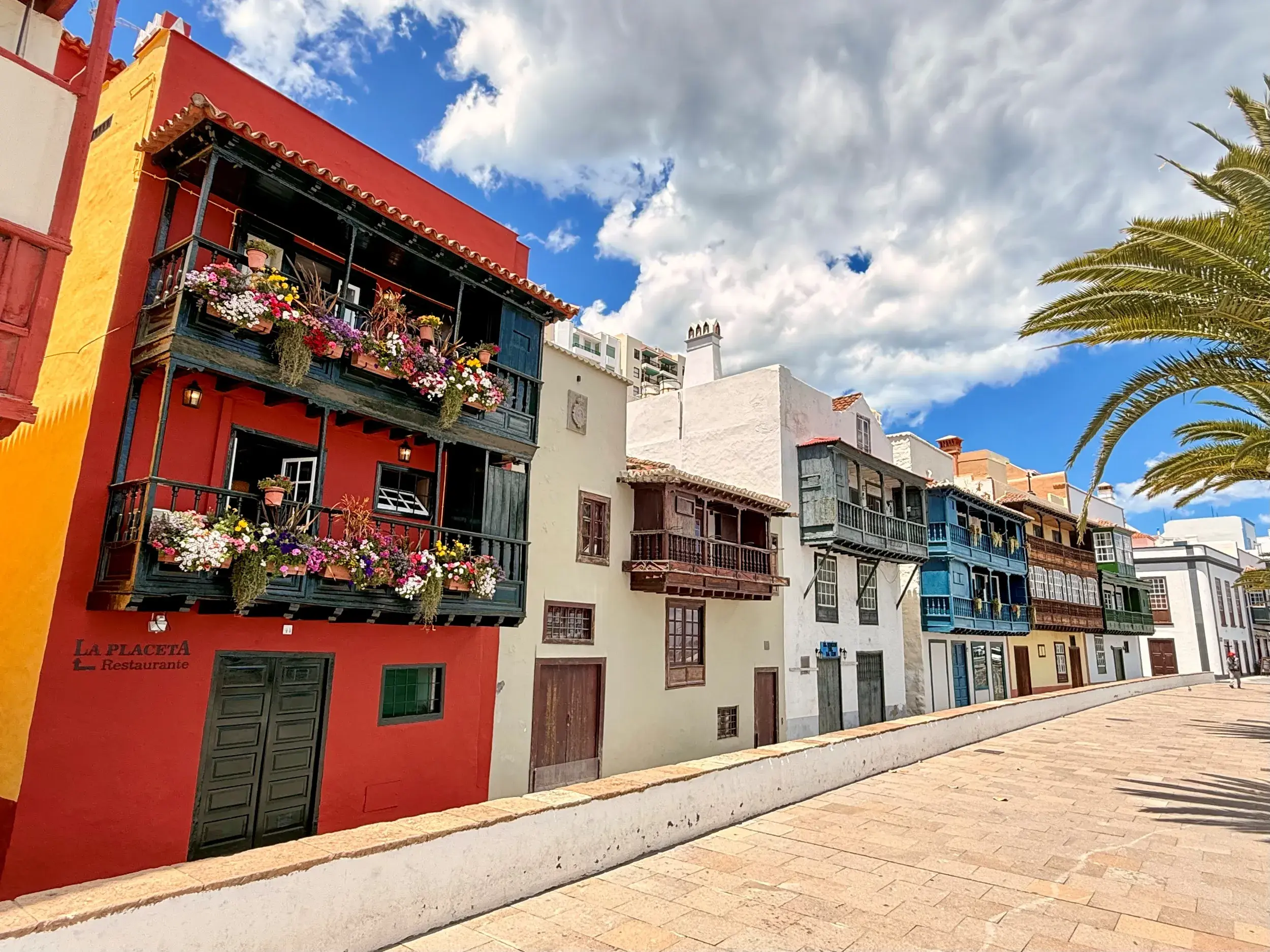 Bunte Häuserfassaden mit blumengeschmückten Holzbalkonen in der kolonialen Altstadt von Santa Cruz de La Palma an einem Sonnentag.