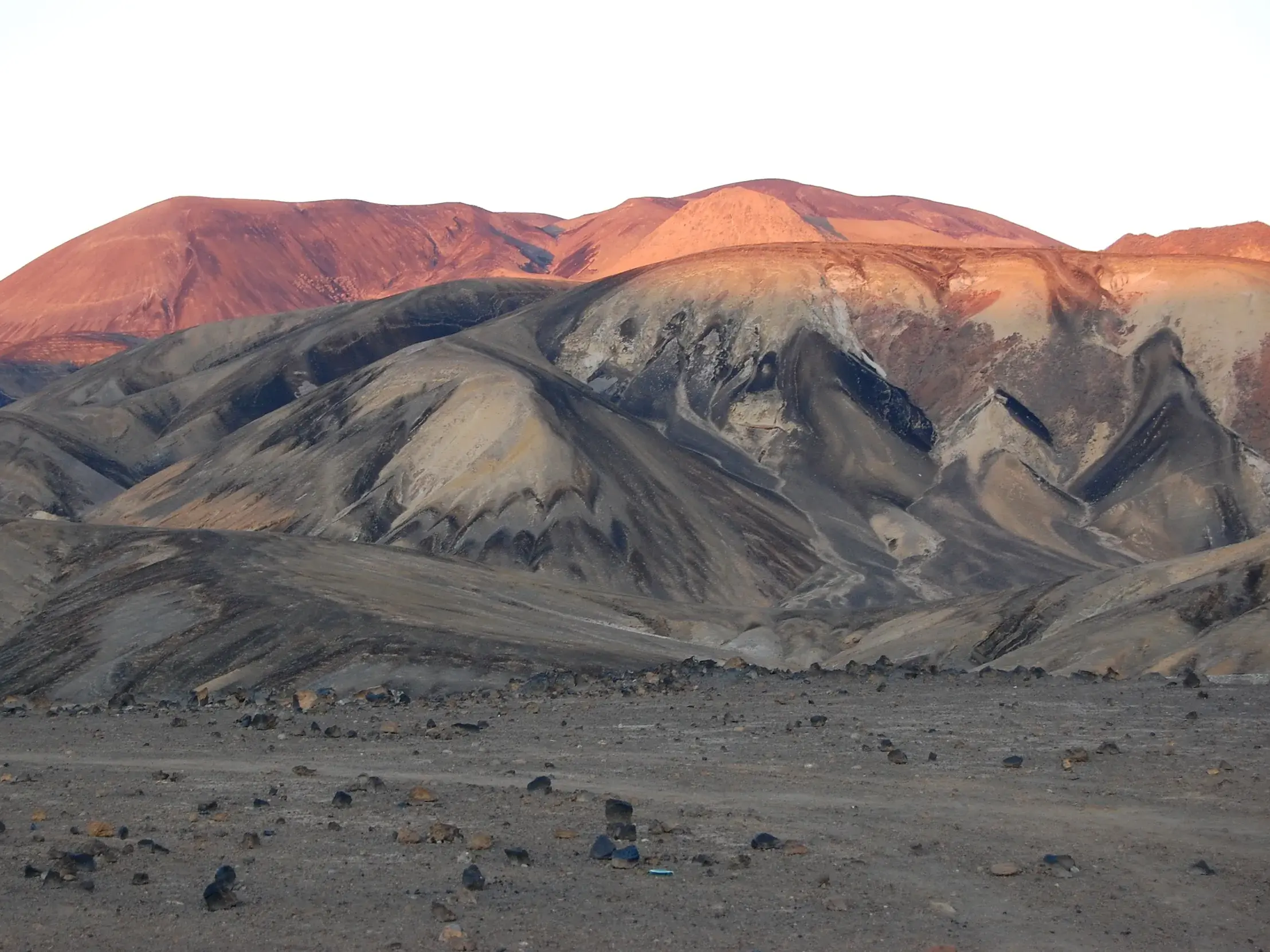 Die Abendsonne taucht die Gipfel der kargen Vulkanlandschaft auf Santo Antão, Kapverden, in ein warmes, rötliches Licht.