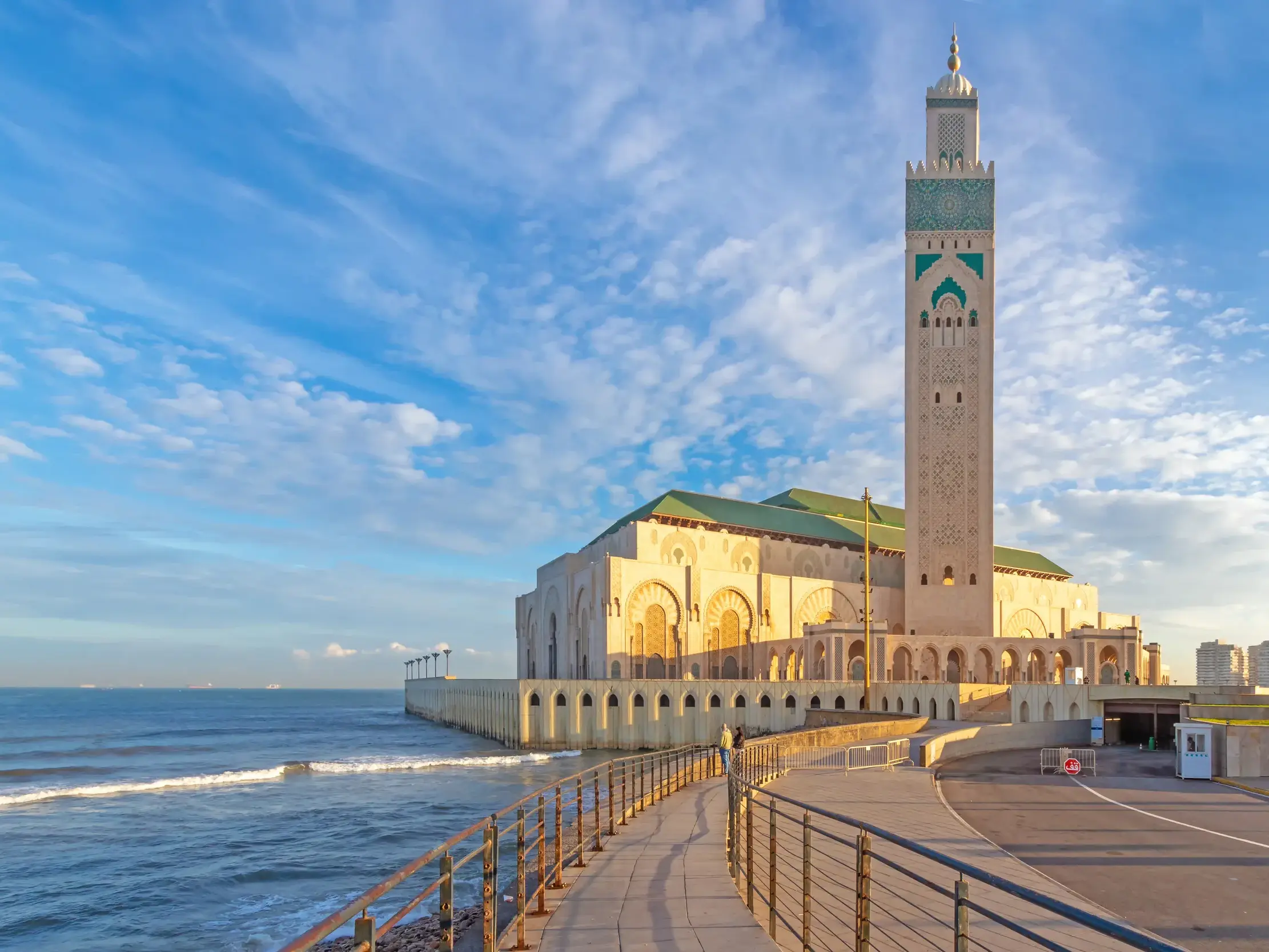 Die beeindruckende Hassan II. Moschee in Casablanca auf einer Landzunge am Atlantik, gesehen von der Uferpromenade.