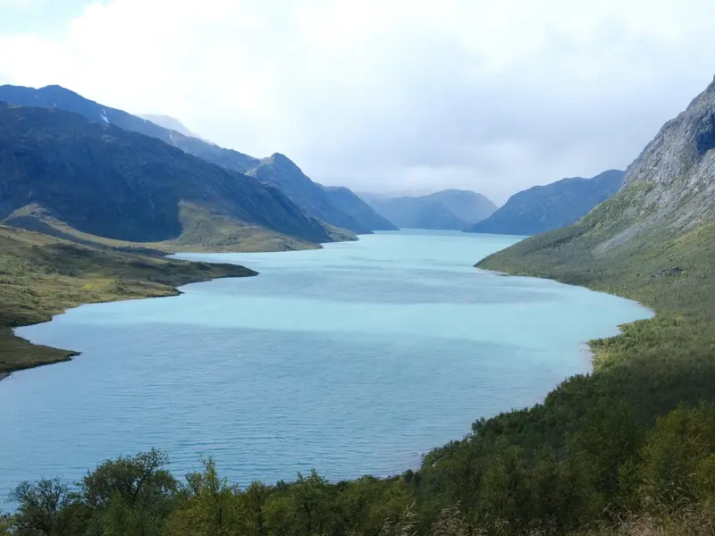 Der türkisfarbene Gjende-See schlängelt sich durch die raue Berglandschaft des Jotunheimen Nationalparks in Norwegen.