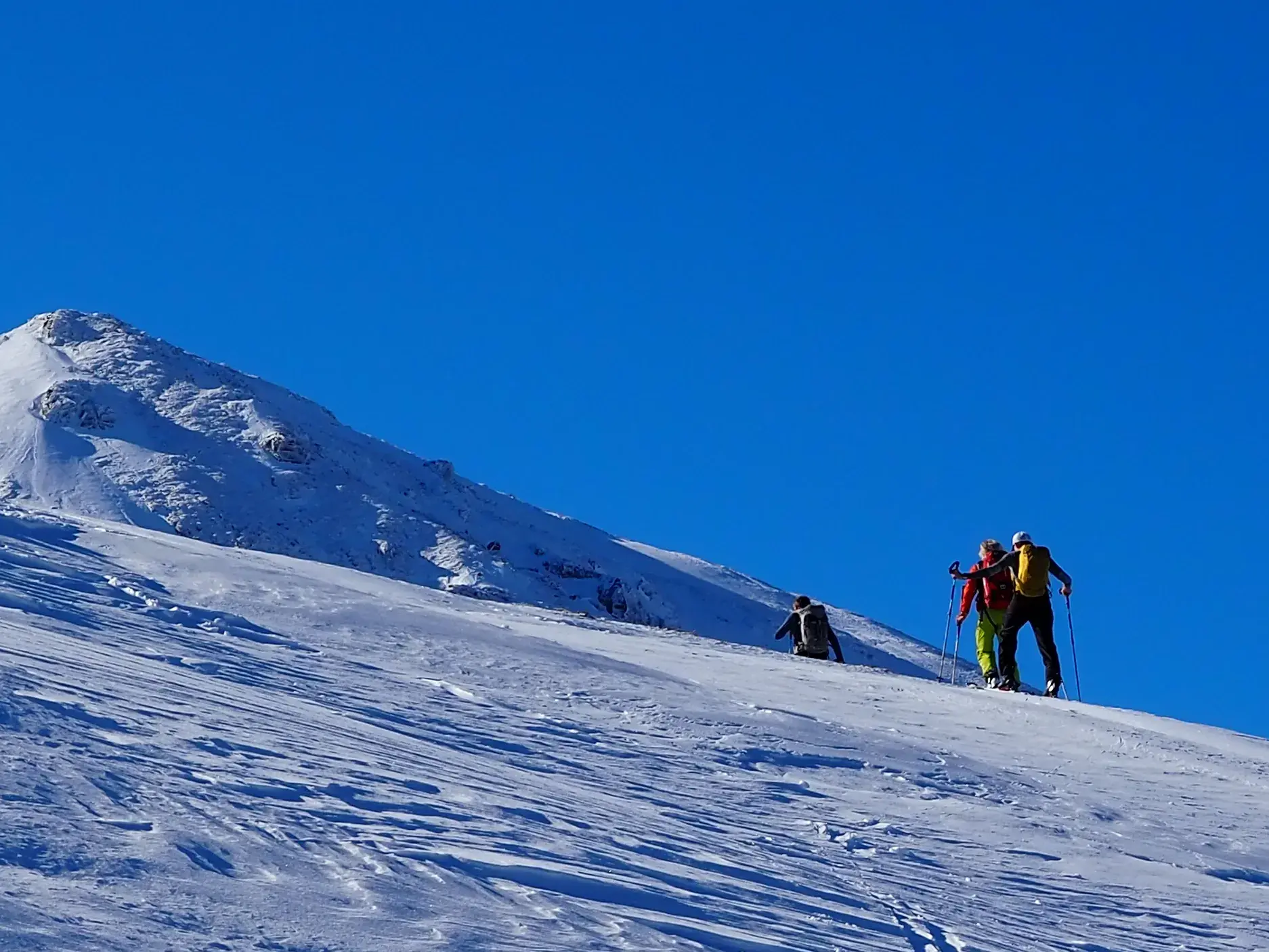 Eine kleine Gruppe von Skitourengehern auf dem Weg zum Gipfel im tiefverschneiten Korab-Gebirge in Albanien.