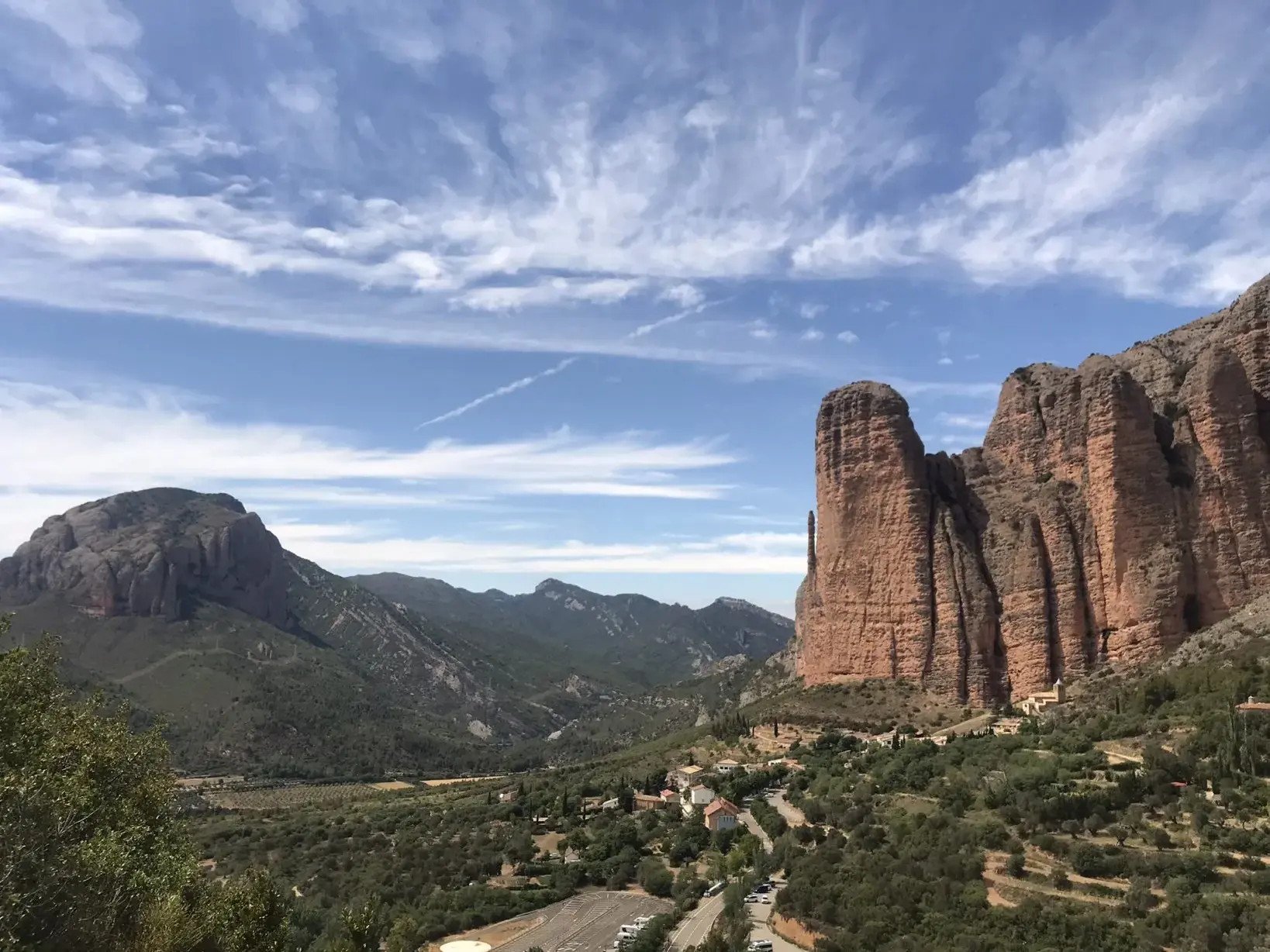 Majestätische, rote Felsen ragen über einem grünen Tal in der Sierra de Guara, ein Highlight auf der Wanderreise in Aragonien.