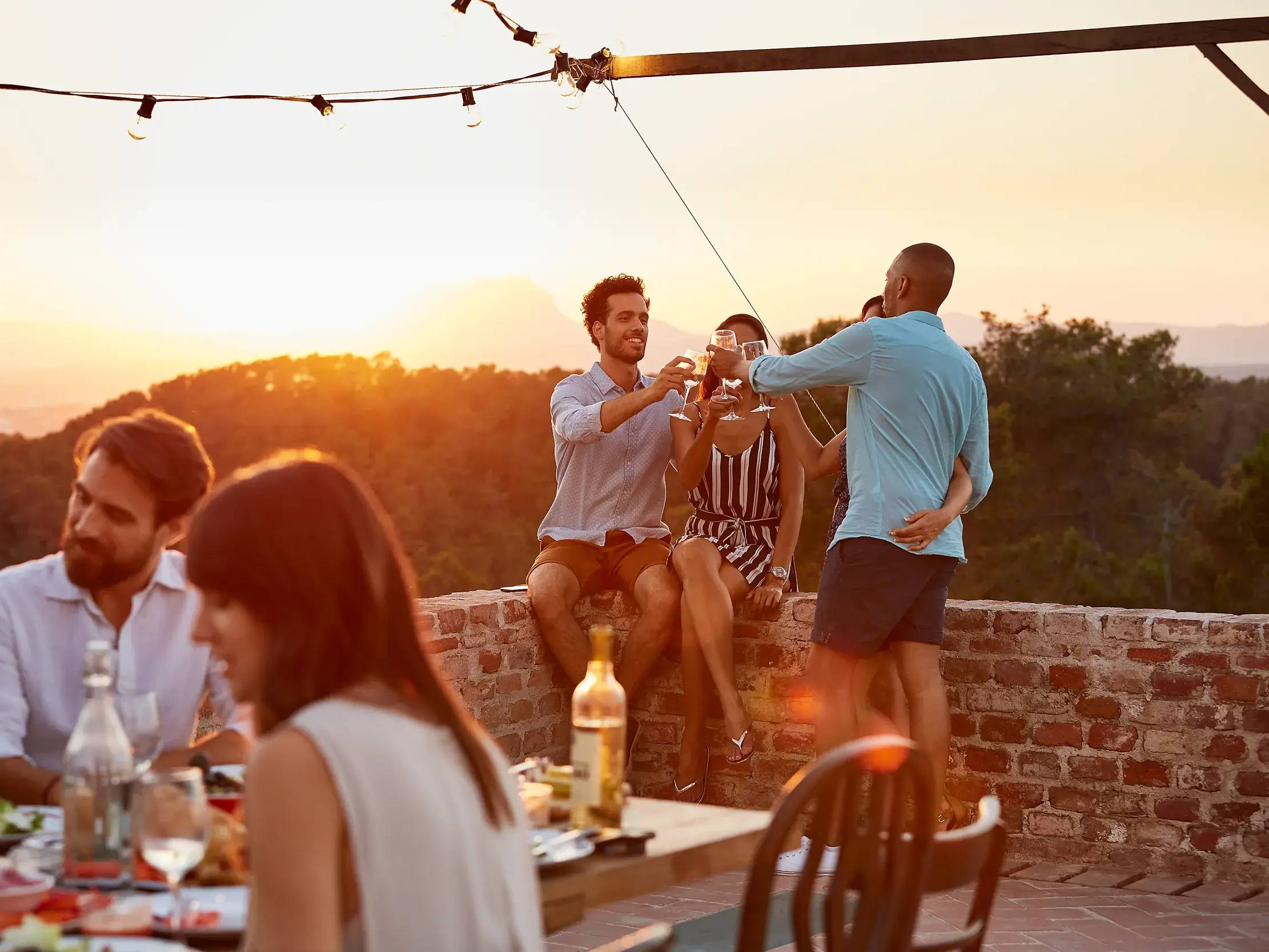 Marco Polo Reisegruppe genießt das Abendessen mit Wein in einer Taverne auf Naxos bei malerischem Sonnenuntergang.