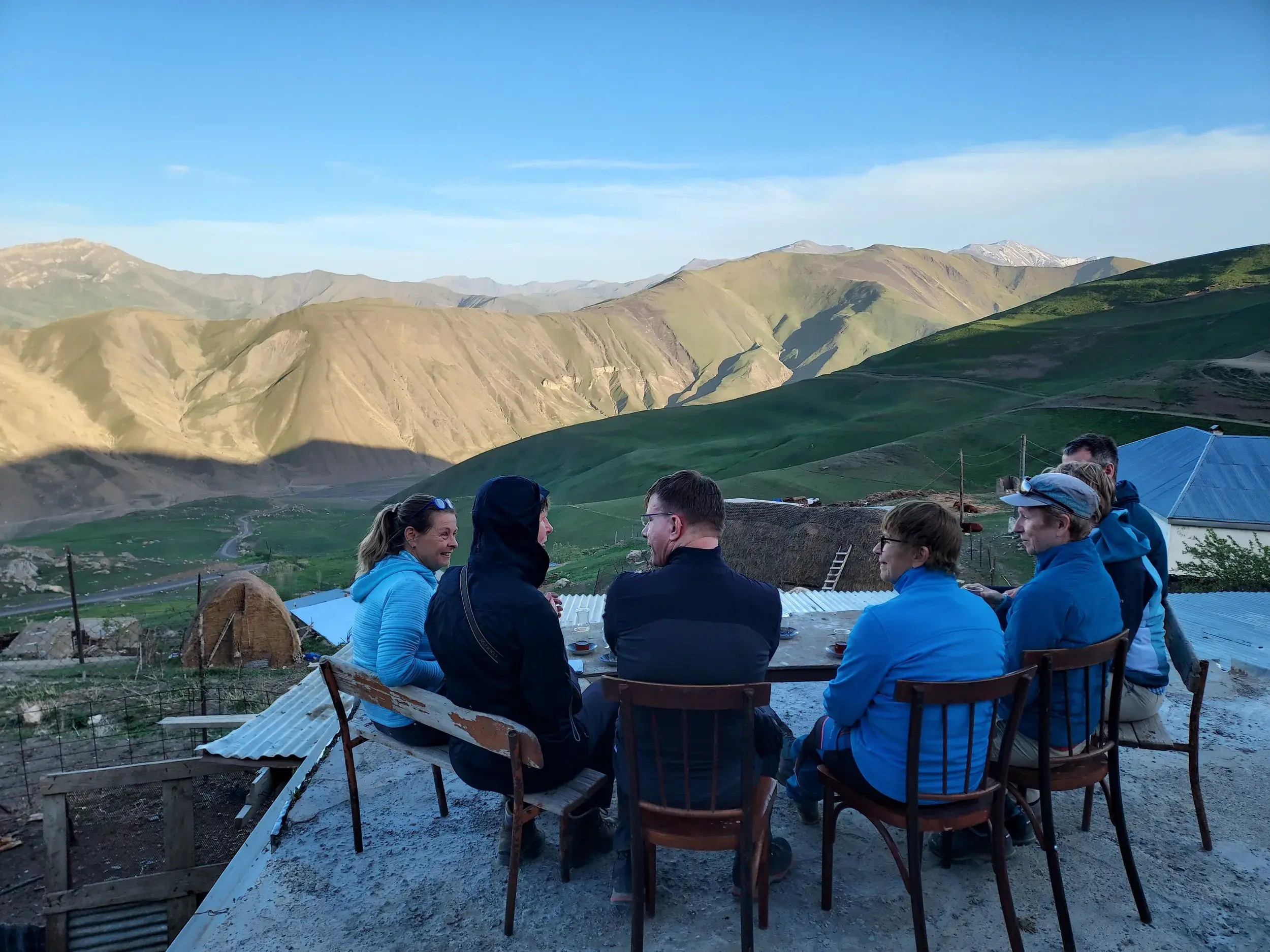Eine Hauser-Reisegruppe genießt Tee auf einer Dachterrasse in einem Homestay im Großen Kaukasus in Aserbaidschan.