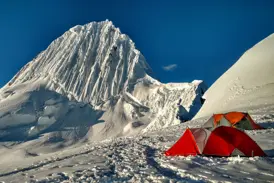 Zwei Zelte im Alpamayo-Hochlager in der Cordillera Blanca mit Blick auf den schneebedeckten Gipfel des Alpamayo.