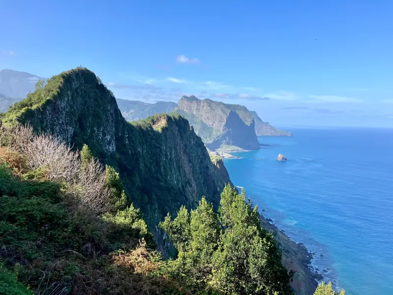 Atemberaubender Ausblick beim Wandern auf die grüne, felsige Nordküste von Madeira und den tiefblauen Atlantischen Ozean.