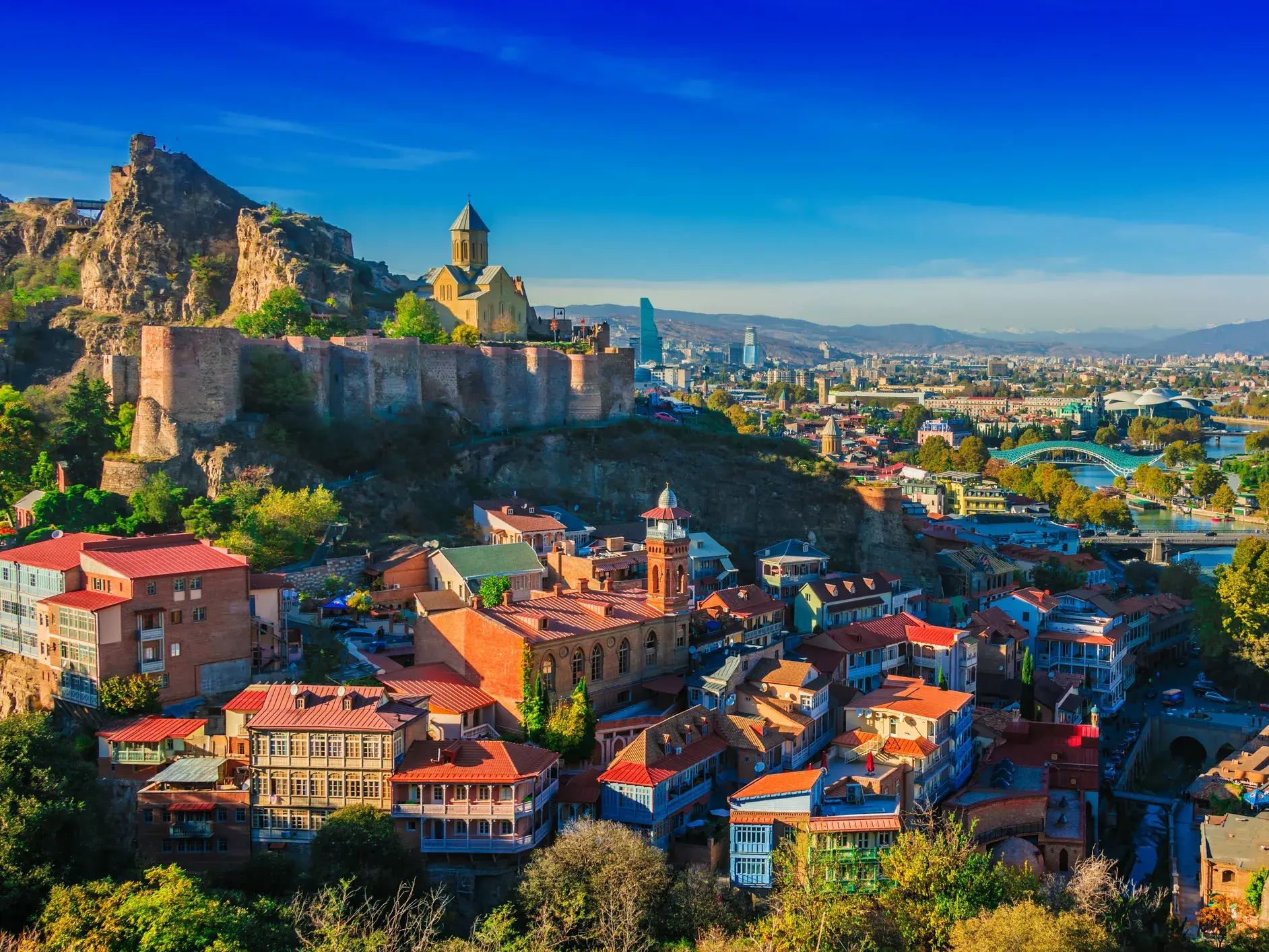 Malerischer Blick auf die Altstadt von Tiflis mit der Narikala-Festung und den berühmten Schwefelbädern unter blauem Himmel.