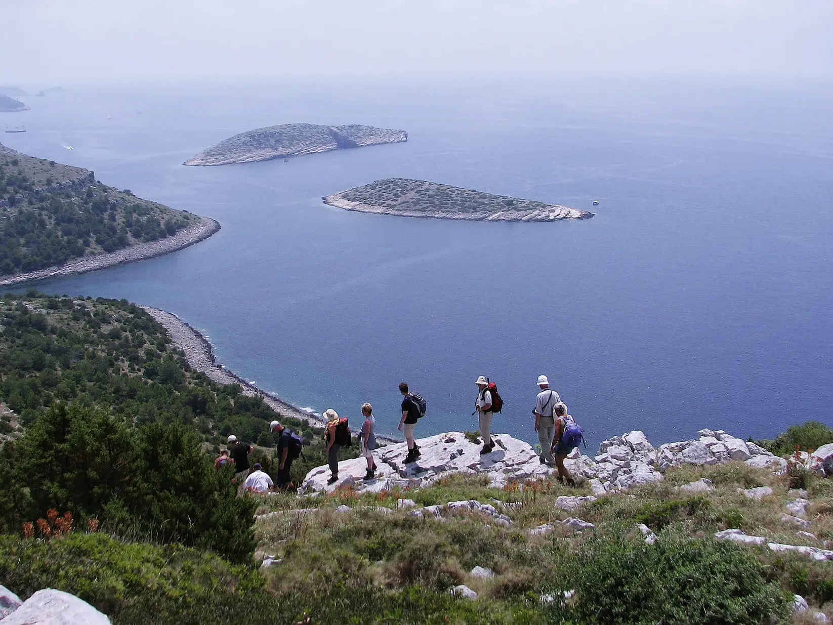 Eine Wandergruppe genießt beim Trekking auf dem Bojin Kuk im Velebit-Gebirge den Ausblick auf die kroatische Inselwelt.