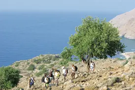 Eine Hauser Exkursionen Wandergruppe auf einem felsigen Küstenpfad mit weitem Blick über den blauen Saronischen Golf in Griechenland.