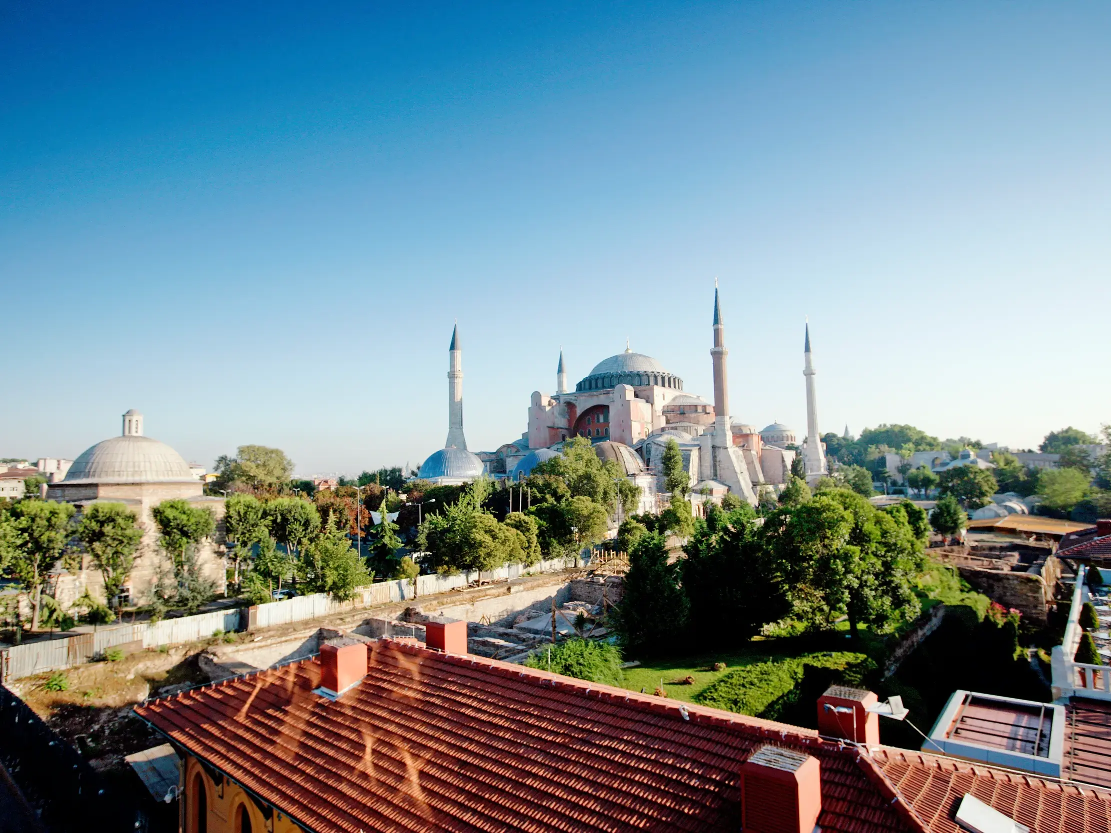 Erhöhter Blick auf die prächtige Hagia Sophia mit ihren Minaretten in Istanbul unter einem klaren, blauen Himmel.