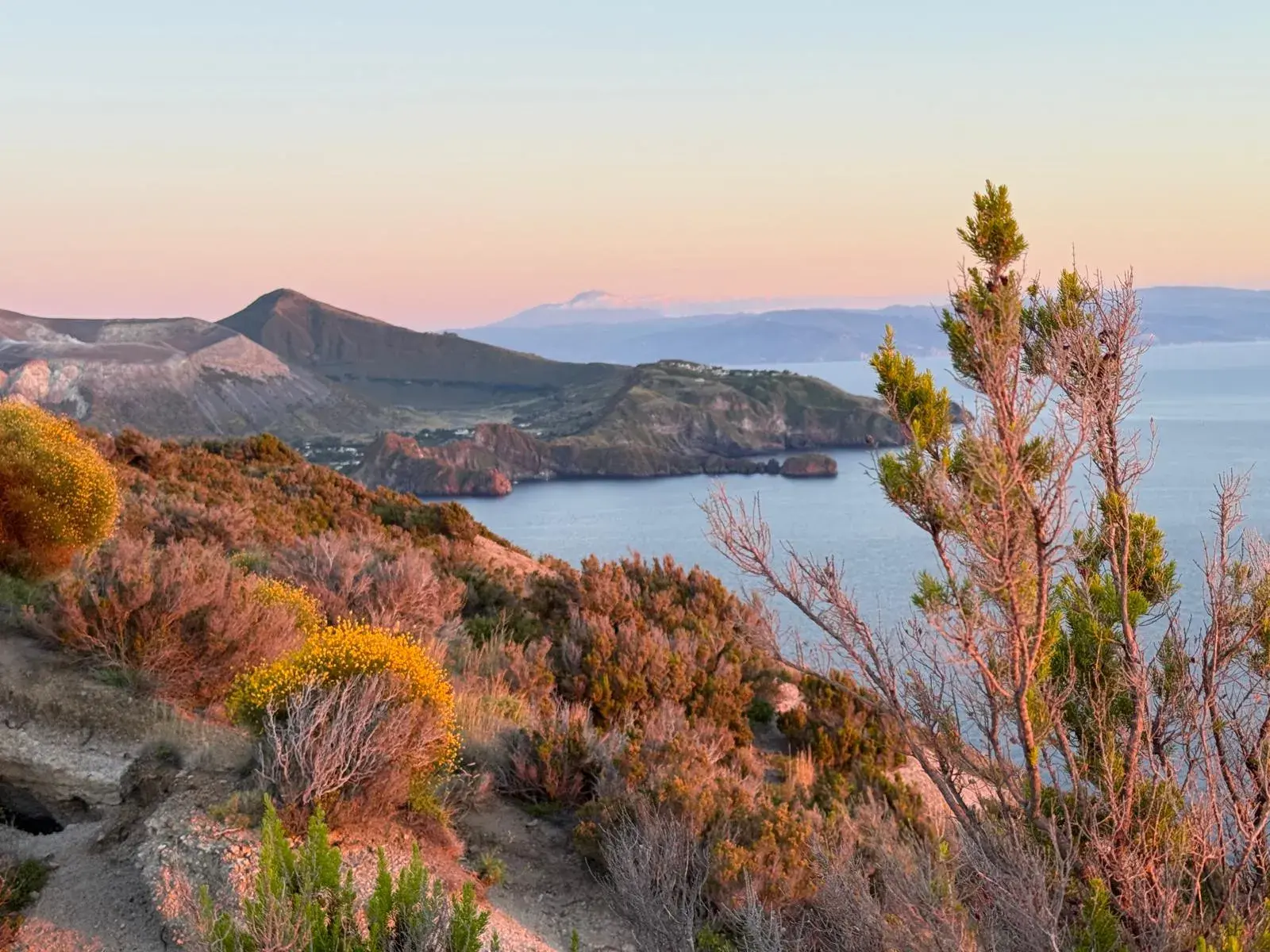 Blick vom Gran Cratere auf der Insel Vulcano über die Küste der Äolischen Inseln zum Ätna bei Sonnenuntergang.